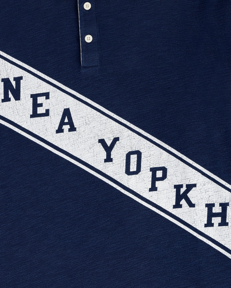 Close-up of the Vintage Slub Rugby in navy, featuring bold white cracked diagonal text reading NEA YOPKH.