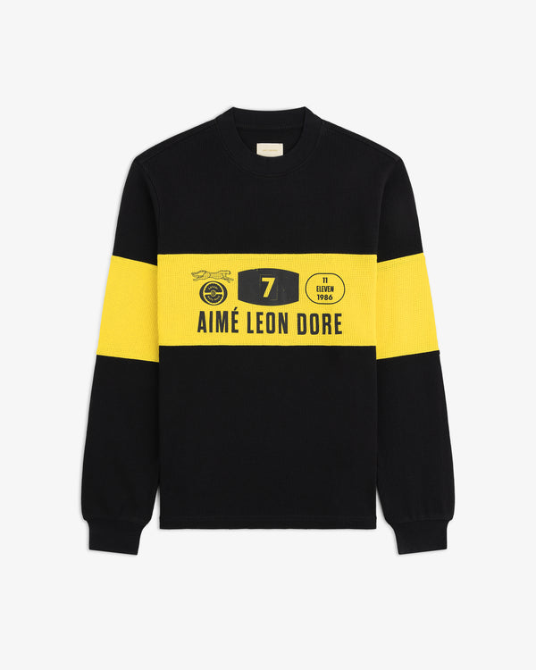 Long-Sleeve Rally Tee: black with yellow stripes, “Aimé Leon Dore” text, racing graphics, and number 7 on chest.