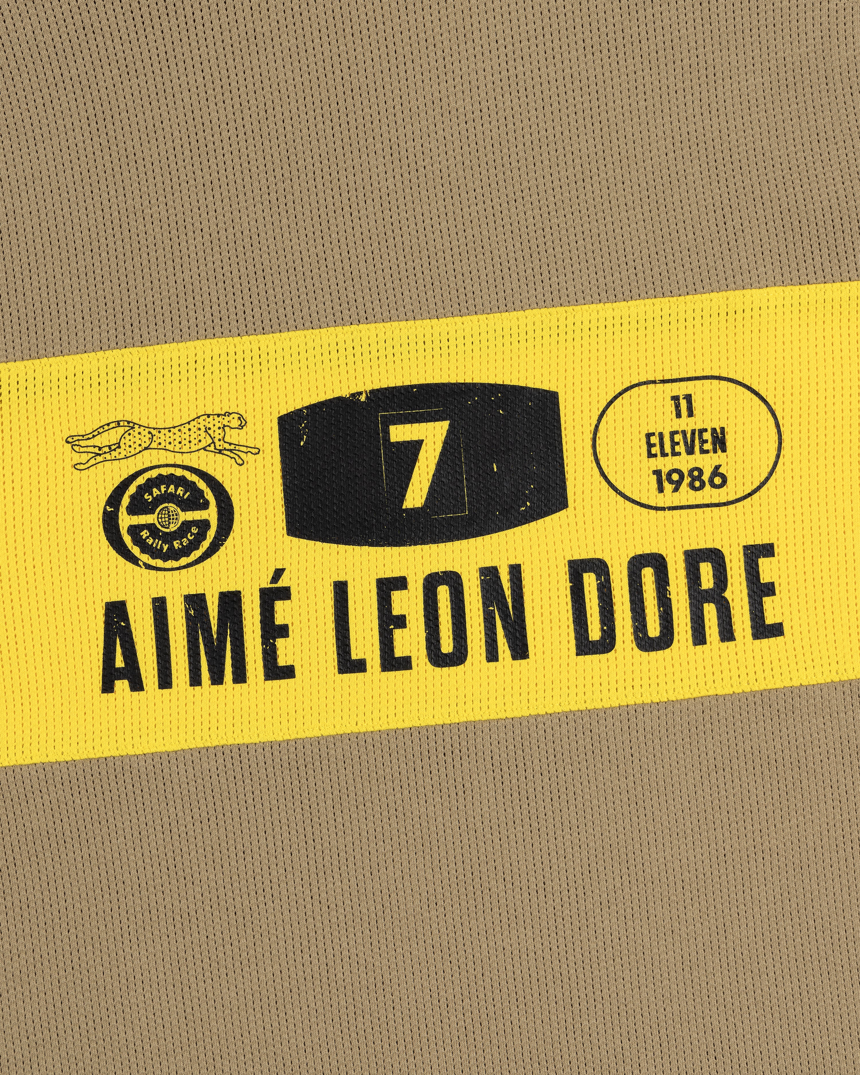A yellow and black patch on the Long-Sleeve Rally Tee reads Aimé Leon Dore with 7, 11 Eleven, and 1986 text.