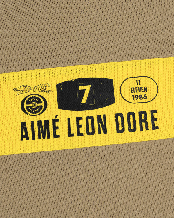 A yellow and black patch on the Long-Sleeve Rally Tee reads Aimé Leon Dore with 7, 11 Eleven, and 1986 text.