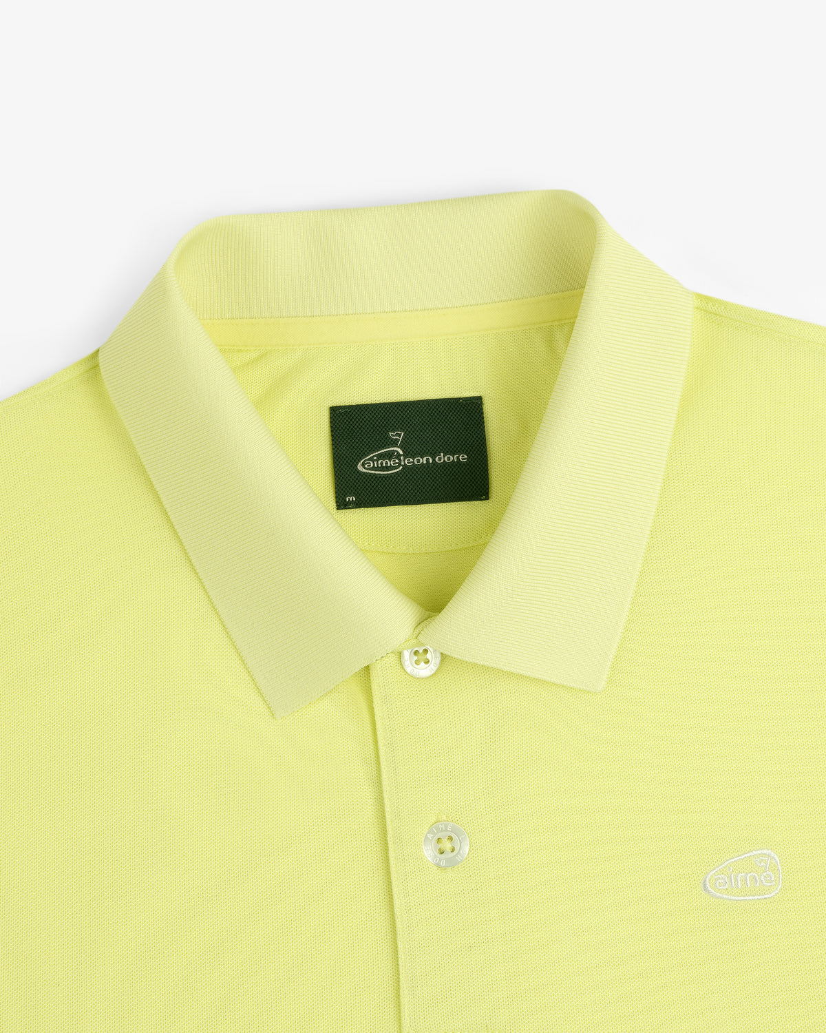 Lemon yellow ALD Golf Polo with a collar, two buttons, and a dark green Aimé Leon Dore neck tag.