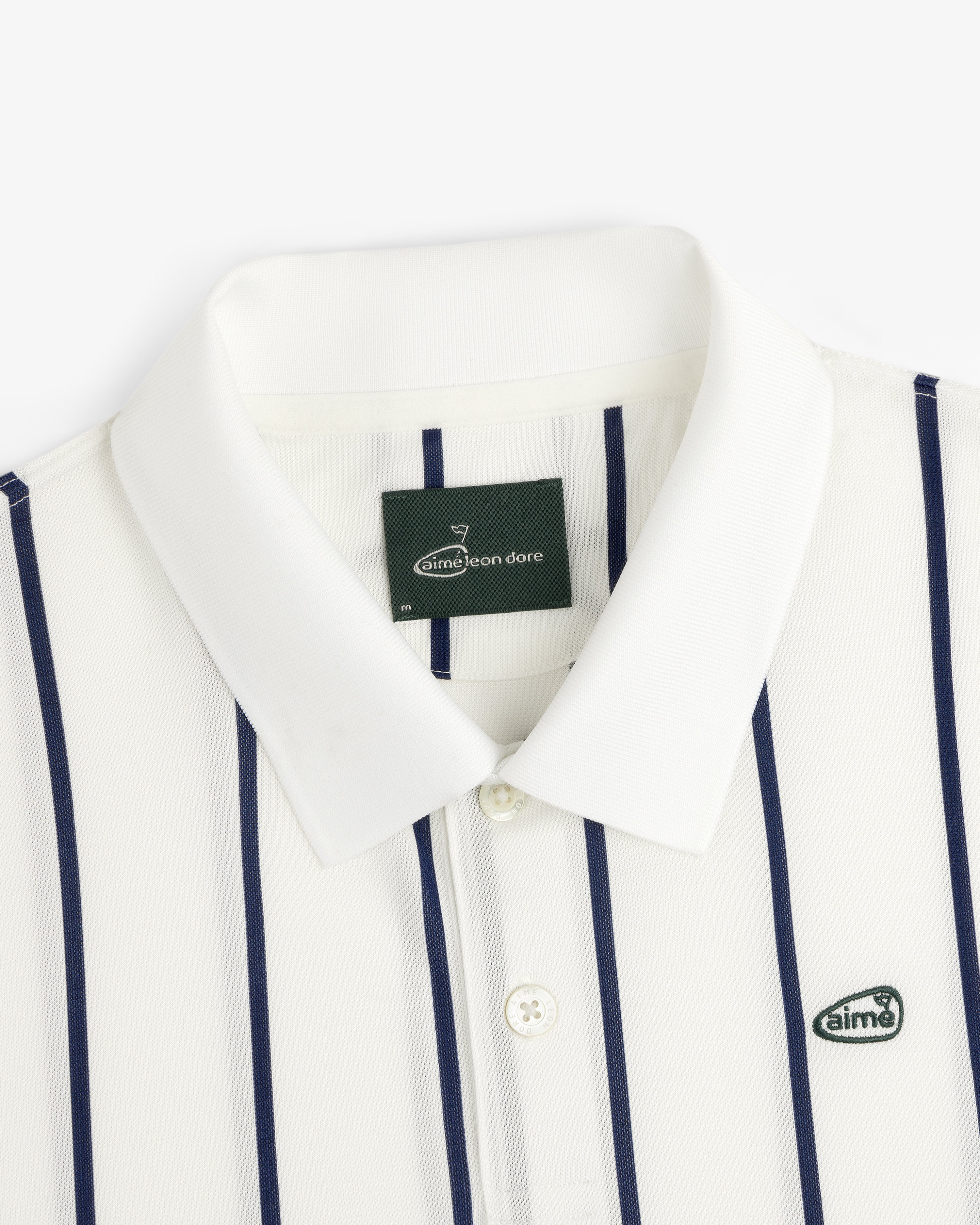 ALD Golf Polo: White with vertical navy stripes and Aimé Leon Dore logo patch on the chest.