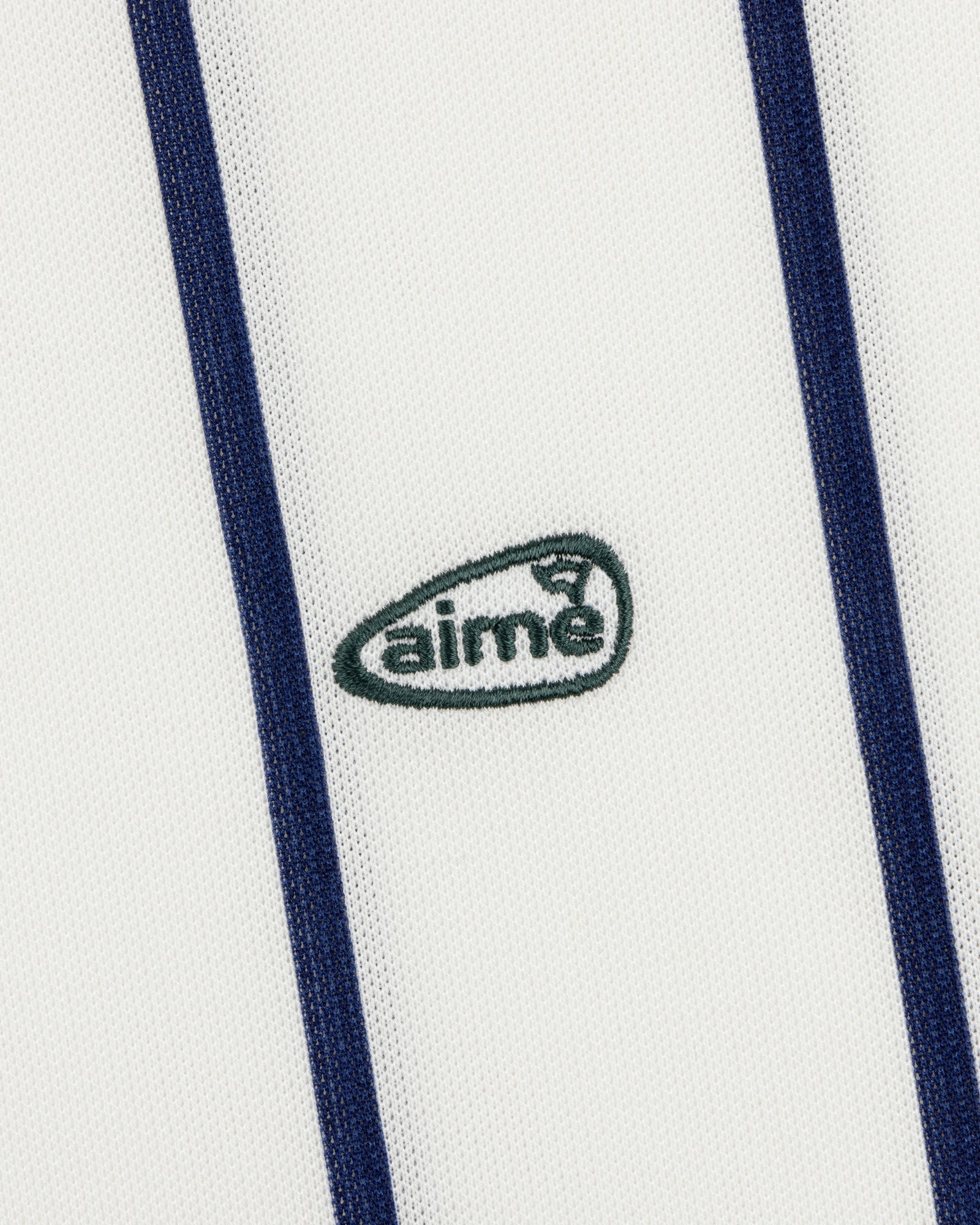 White ALD Golf Polo with vertical navy stripes and a small green aimé logo centered.