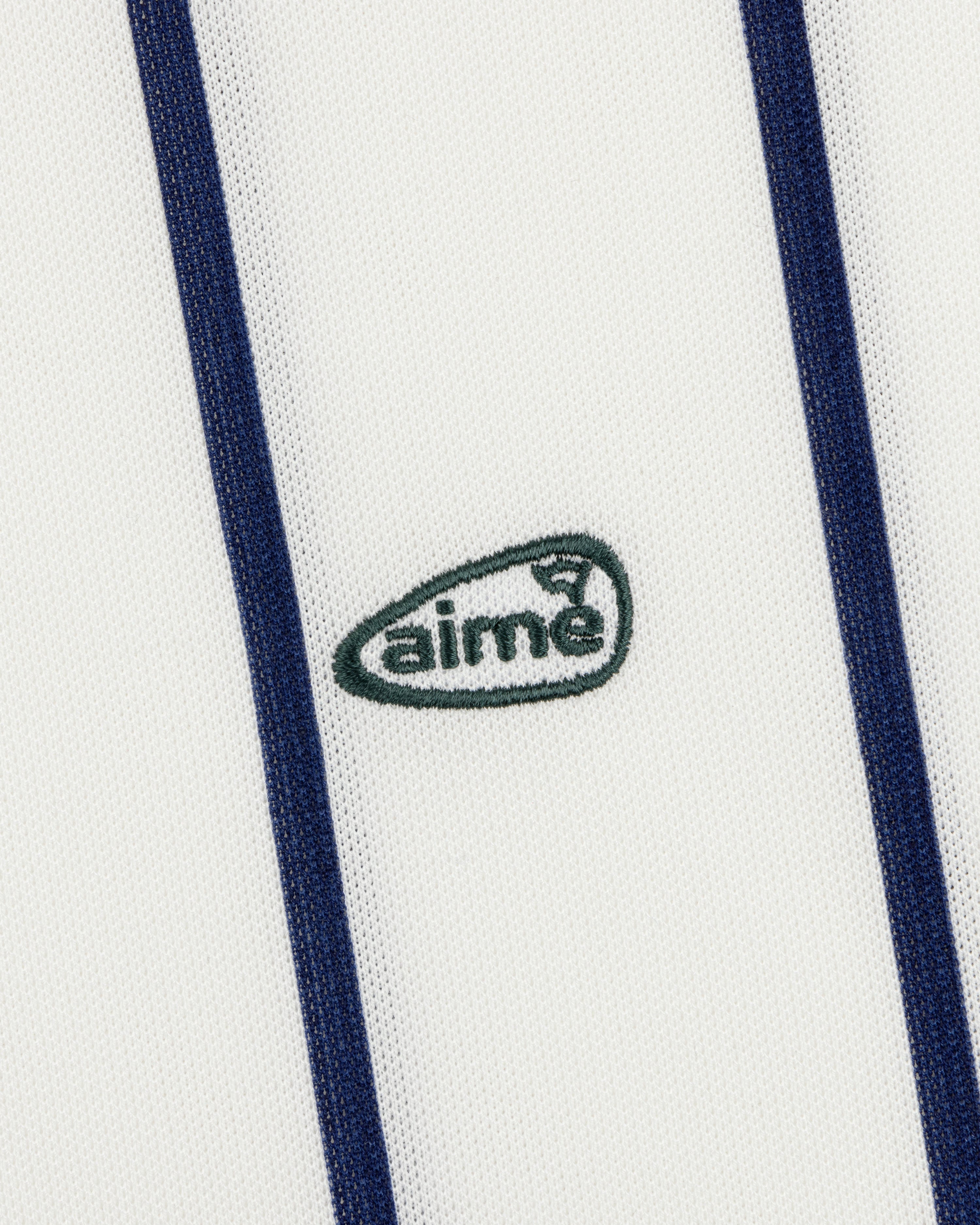 White ALD Golf Polo with vertical navy stripes and a small green aimé logo centered.