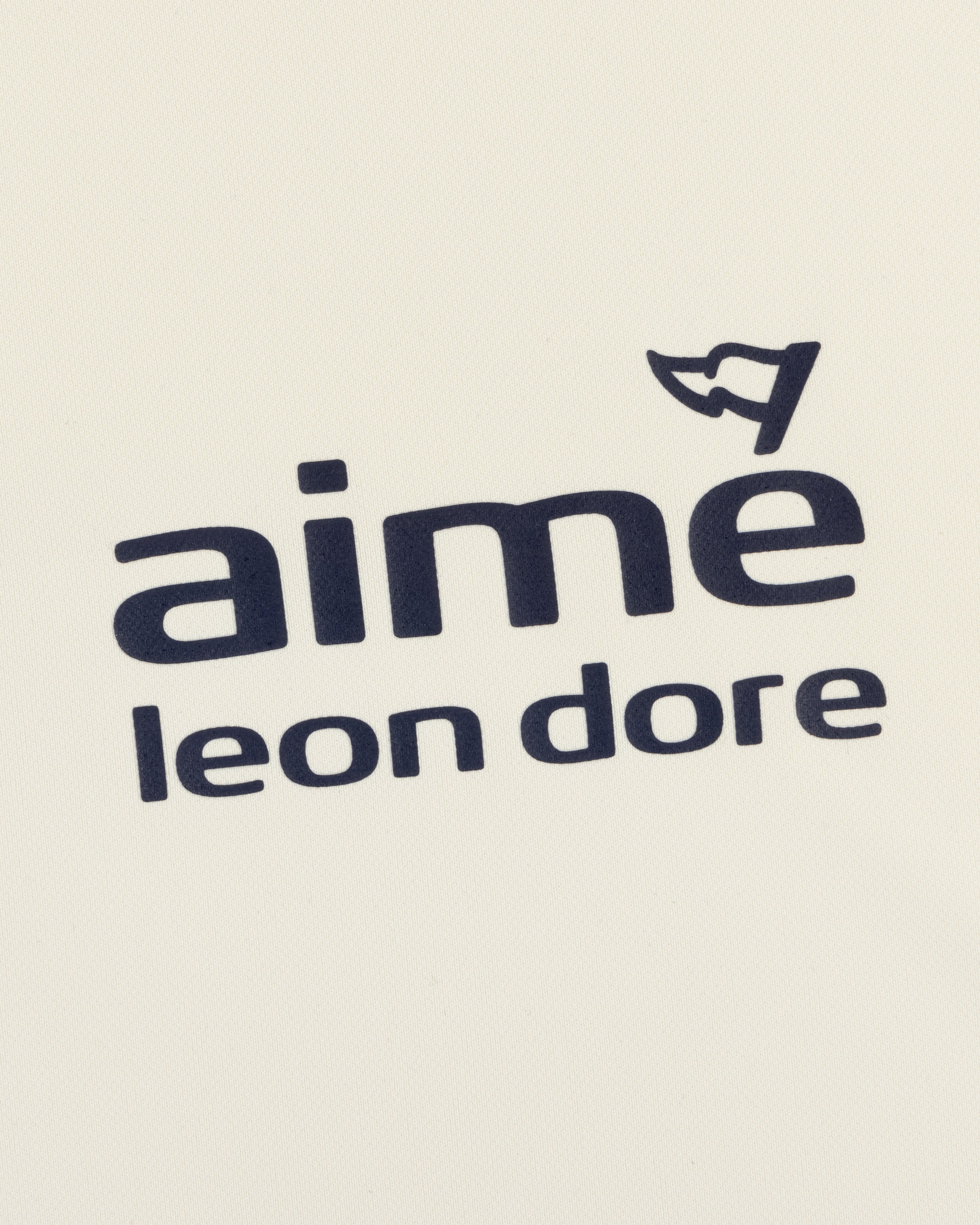 ALD Golf Tour Polo features "Aimé Leon Dore" in black on white, with a small cap graphic above the letter "e".