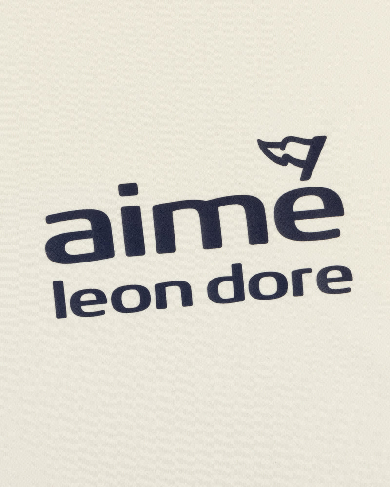 ALD Golf Tour Polo features "Aimé Leon Dore" in black on white, with a small cap graphic above the letter "e".