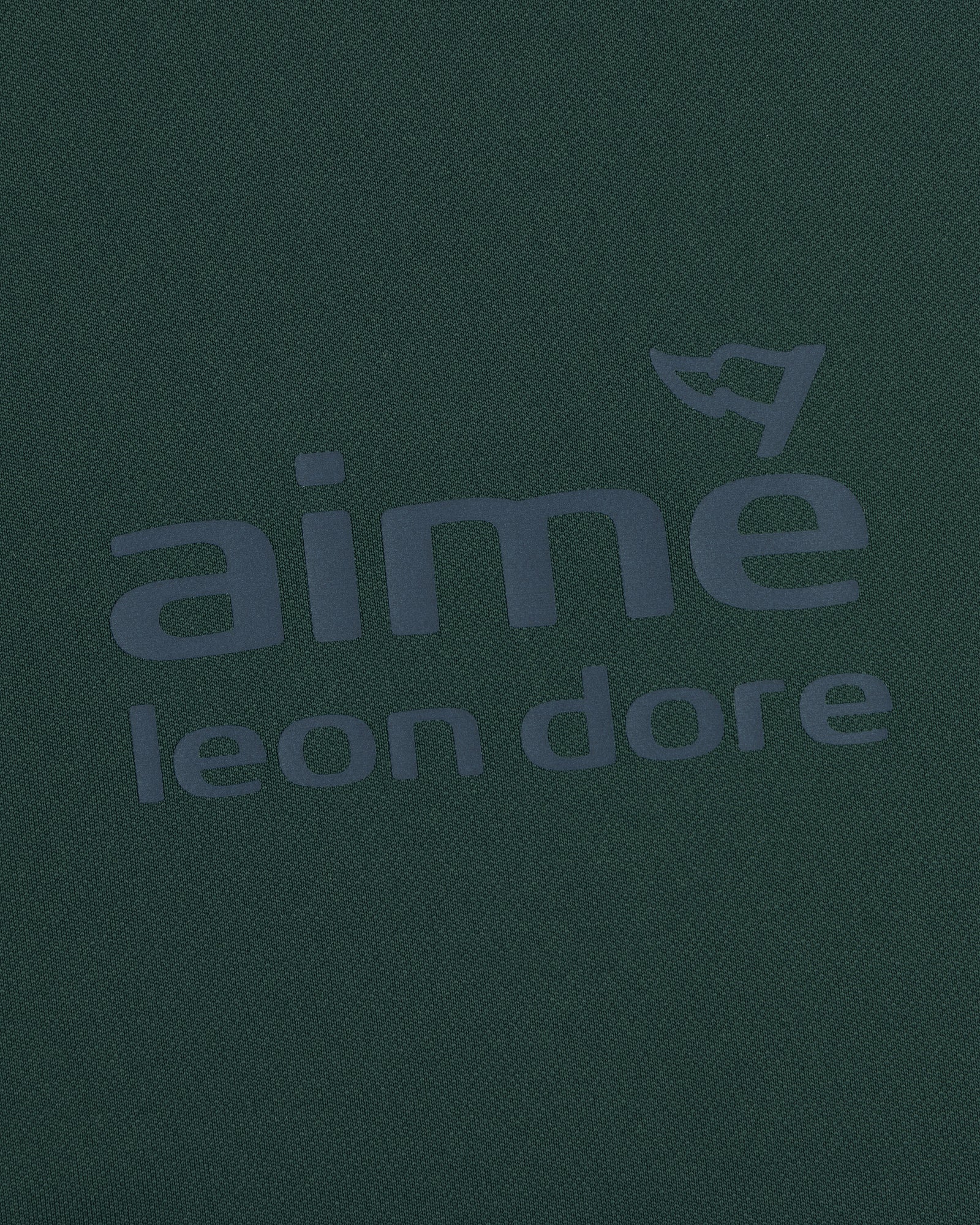 Dark green ALD Golf Tour Polo with gray aimé leon dore logo and a small flag above the letter "e".