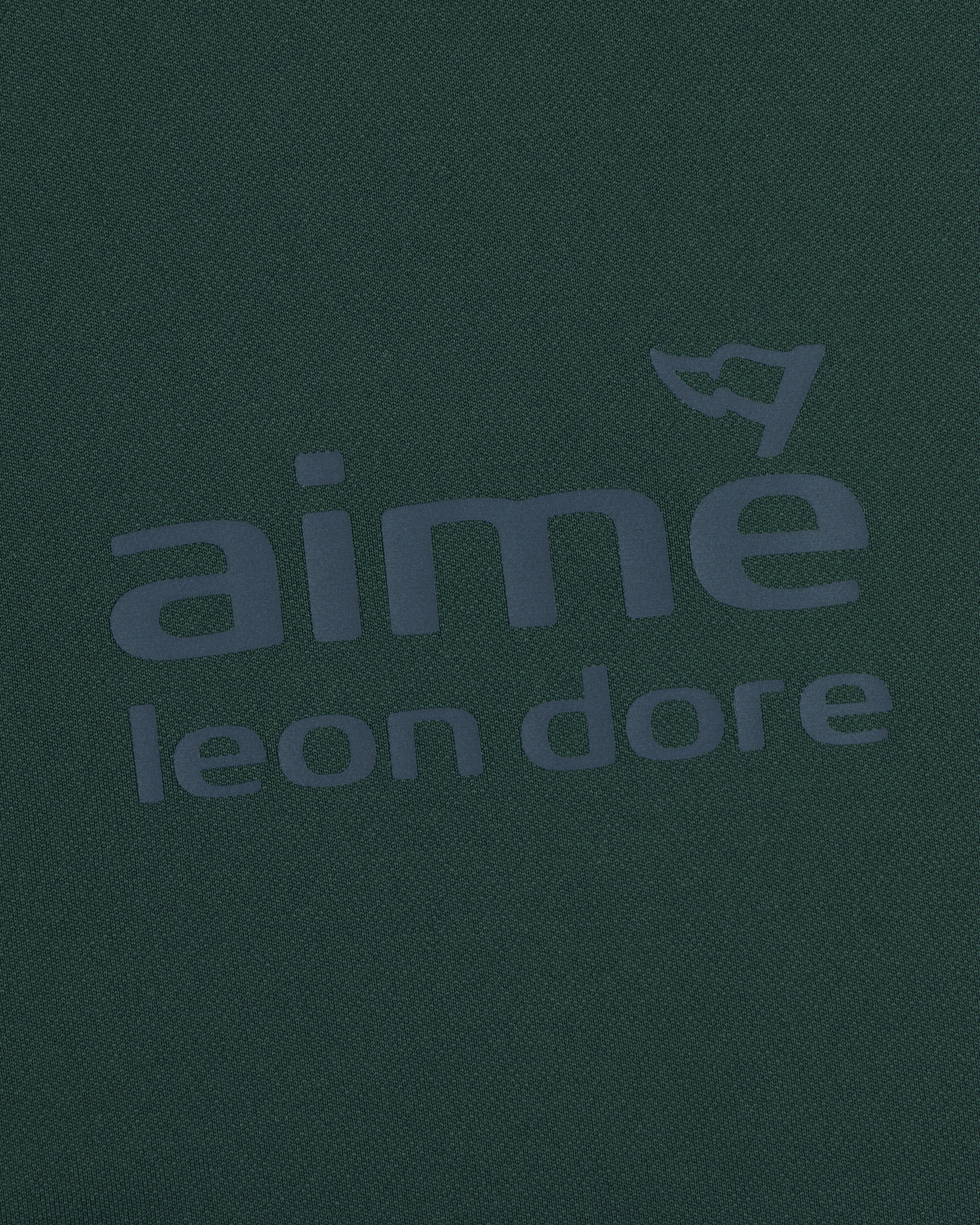 Dark green ALD Golf Tour Polo with gray aimé leon dore logo and a small flag above the letter "e".