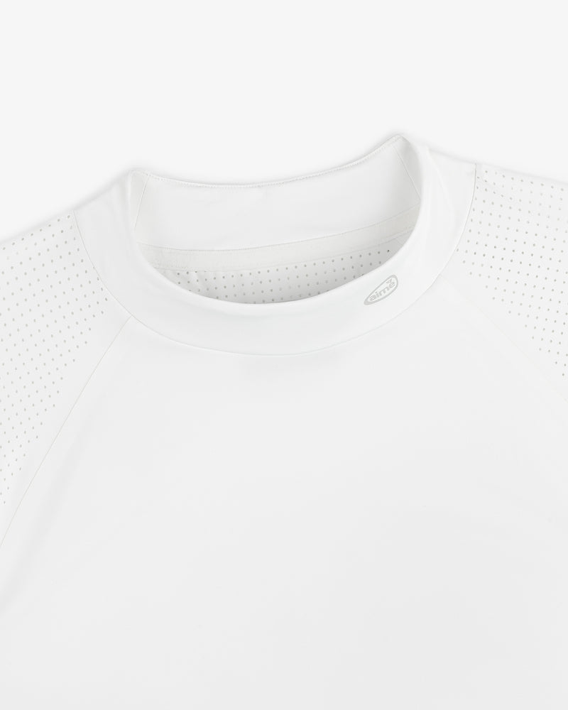 Close-up of the ALD Golf Performance Tee, a white athletic shirt with perforated shoulders and a round neck, laid flat.