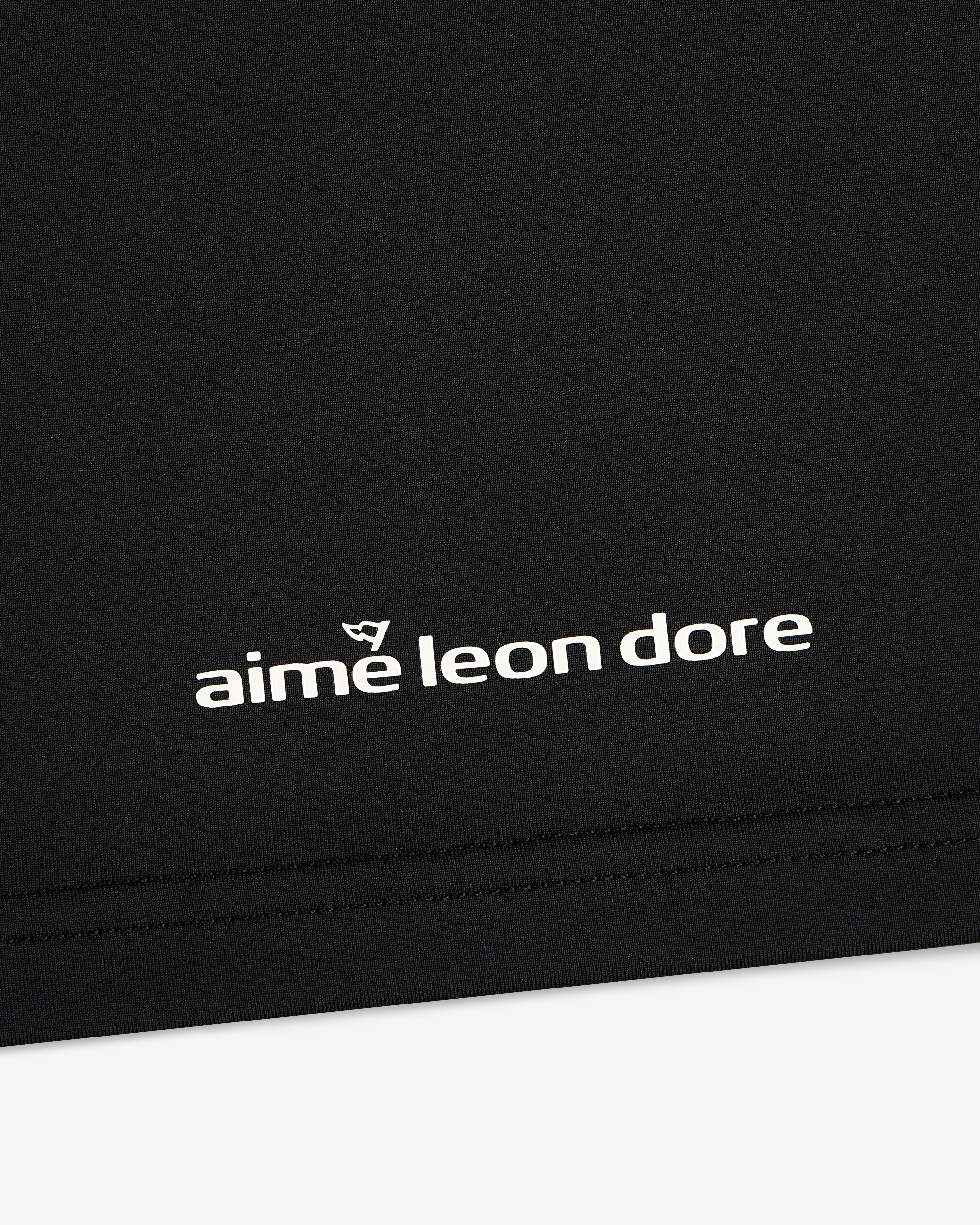 Black ALD Golf Performance Tee featuring white “aime leon dore” text and a small logo above the brand name.