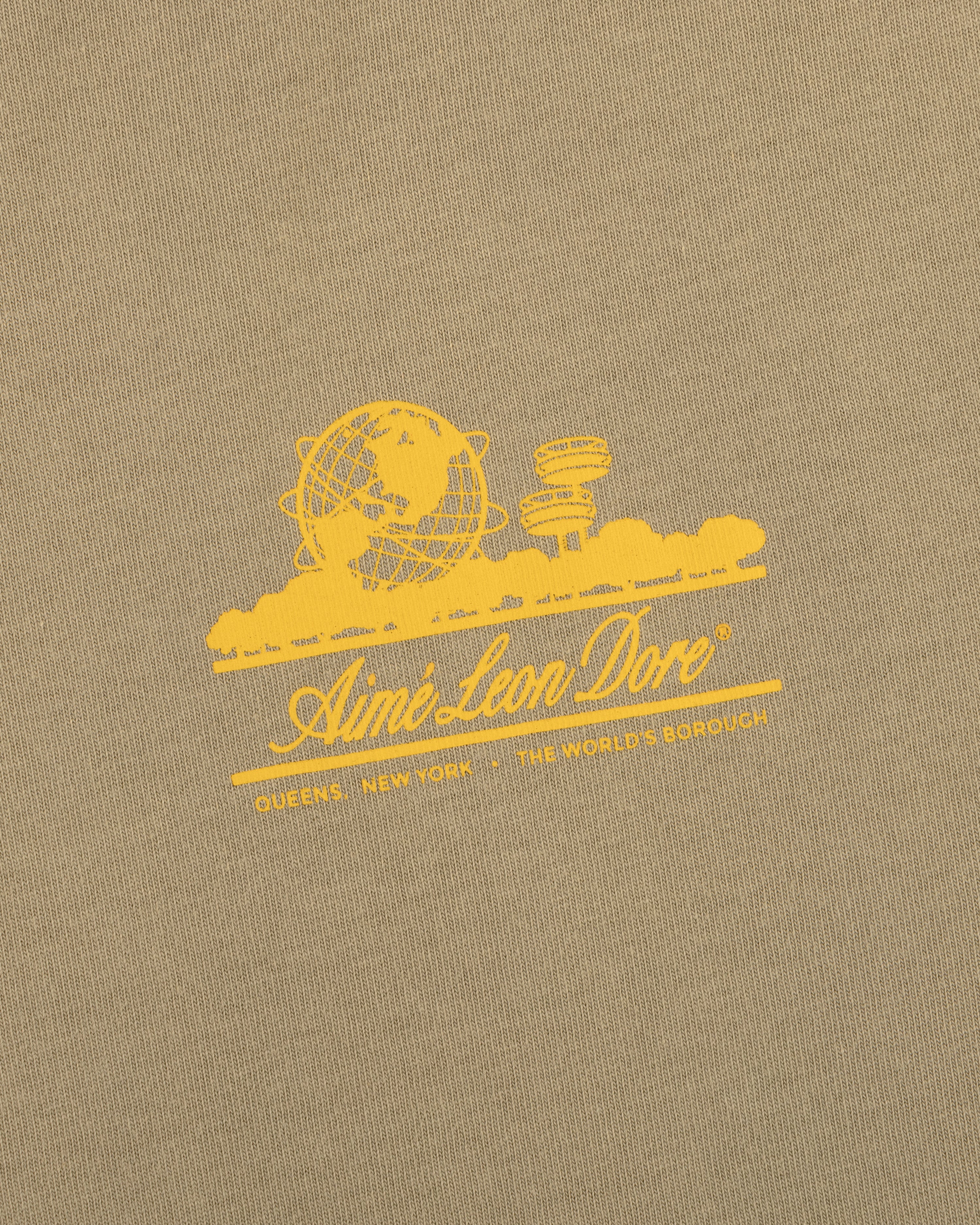 Sun Faded Unisphere Tee: yellow Aimé Leon Dore logo with globe, skyline, and "Queens, New York - The World's Borough.