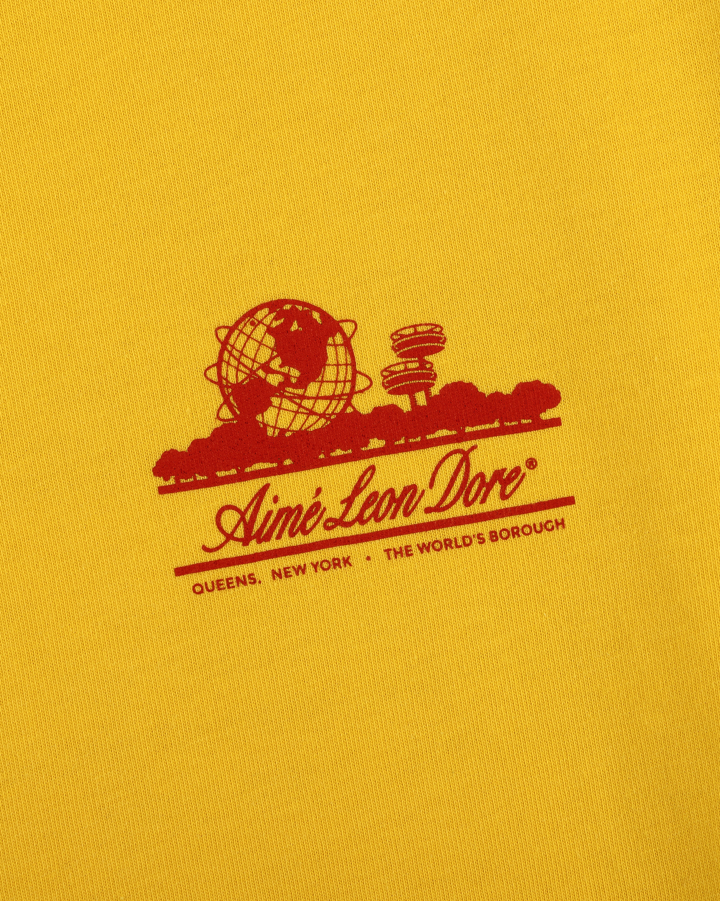 Yellow Sun Faded Unisphere Tee with red globe, skyline, and “Aimé Leon Dore, Queens, New York, The World’s Borough” text.