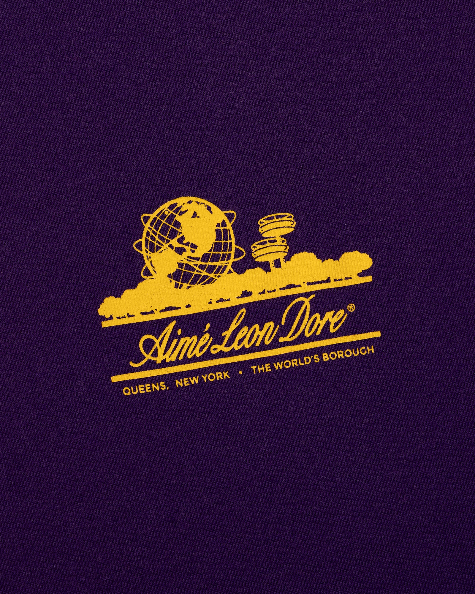 Yellow graphic of the Unisphere and towers with Aimé Leon Dore text on the Sun Faded Unisphere Tee.