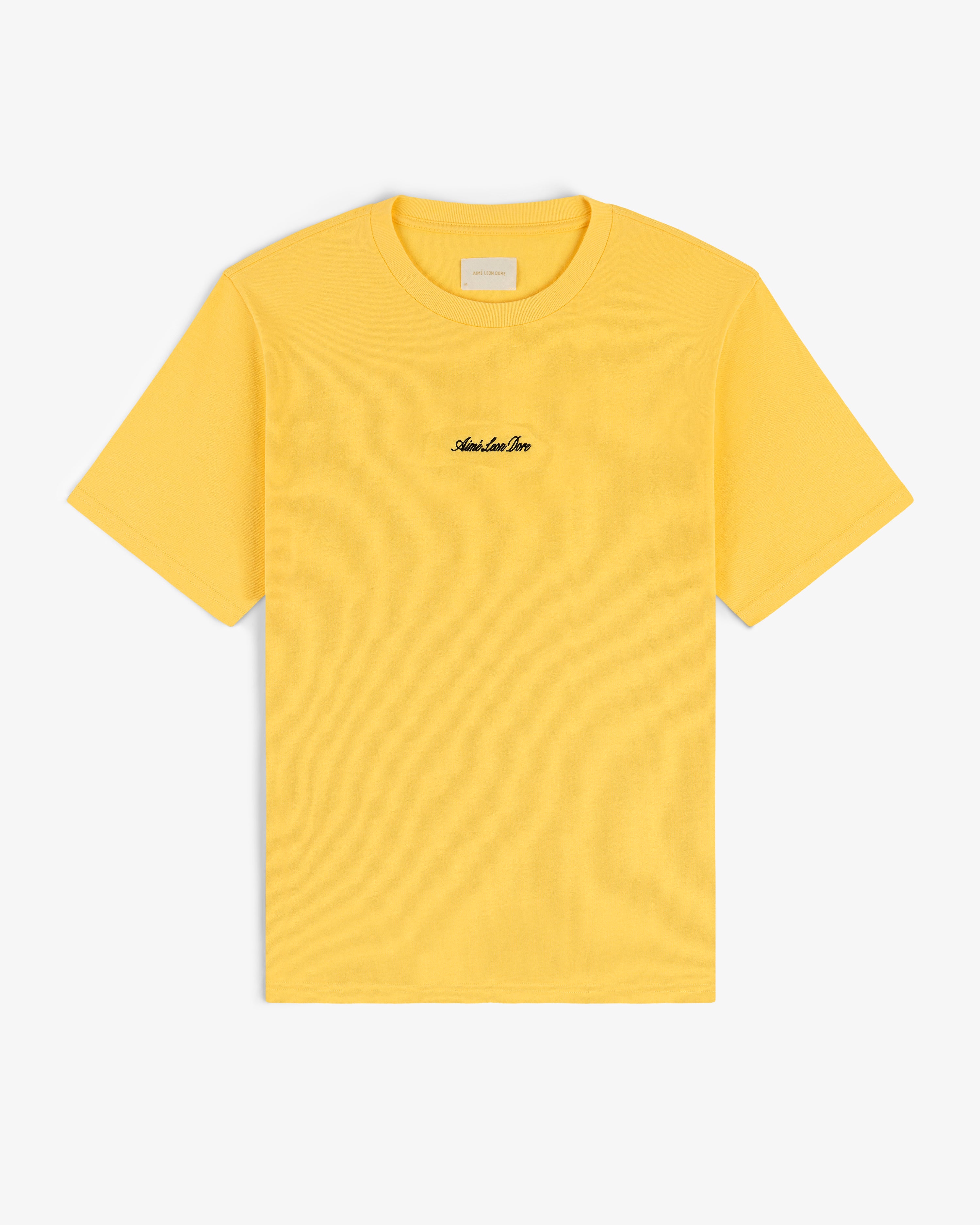 Embroidered Logo Tee in yellow with small black chest text, shown on a white background.