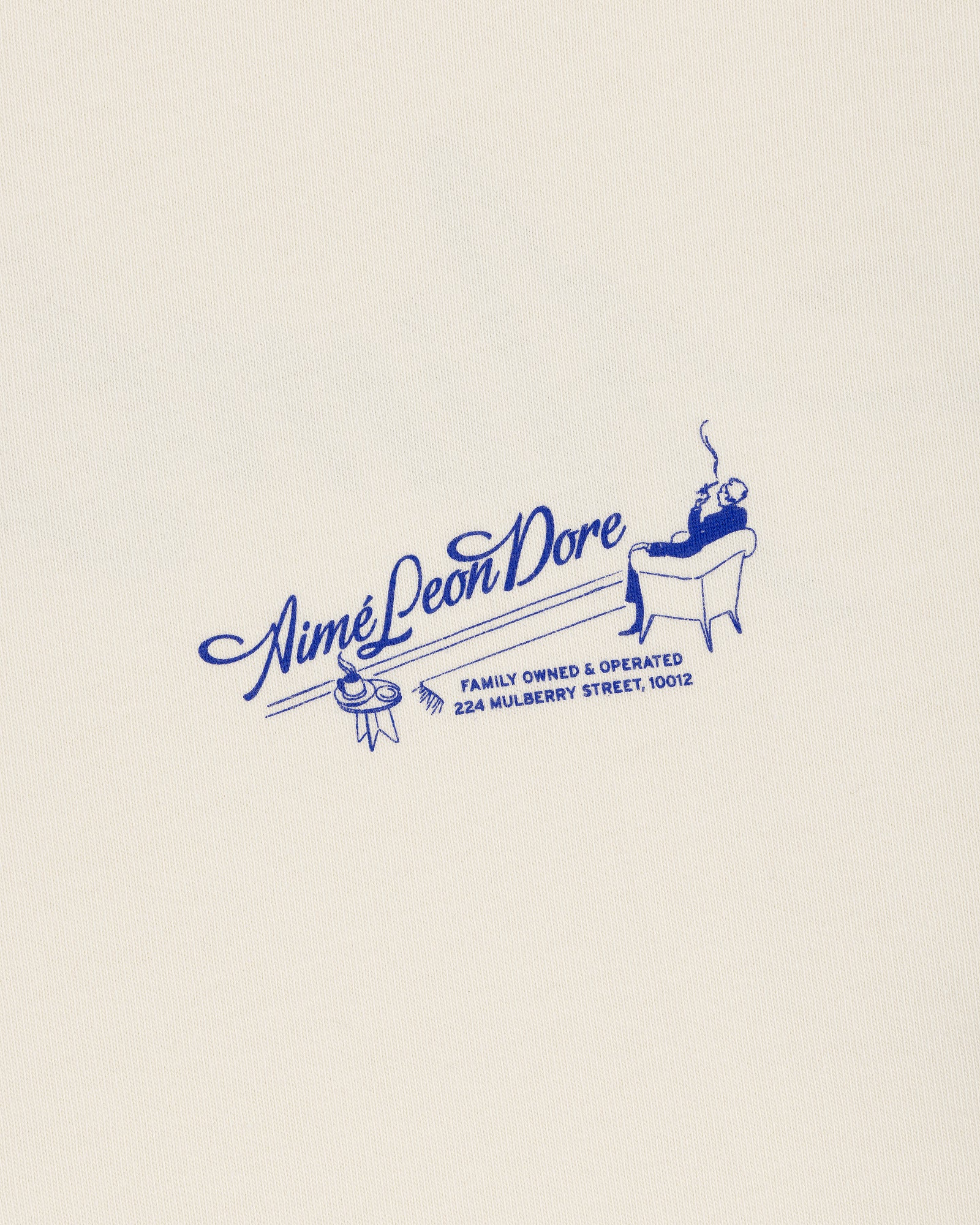 A blue Pappoús Logo Tee by Aimé Leon Dore features a lounging figure and 224 Mulberry Street on a cream background.