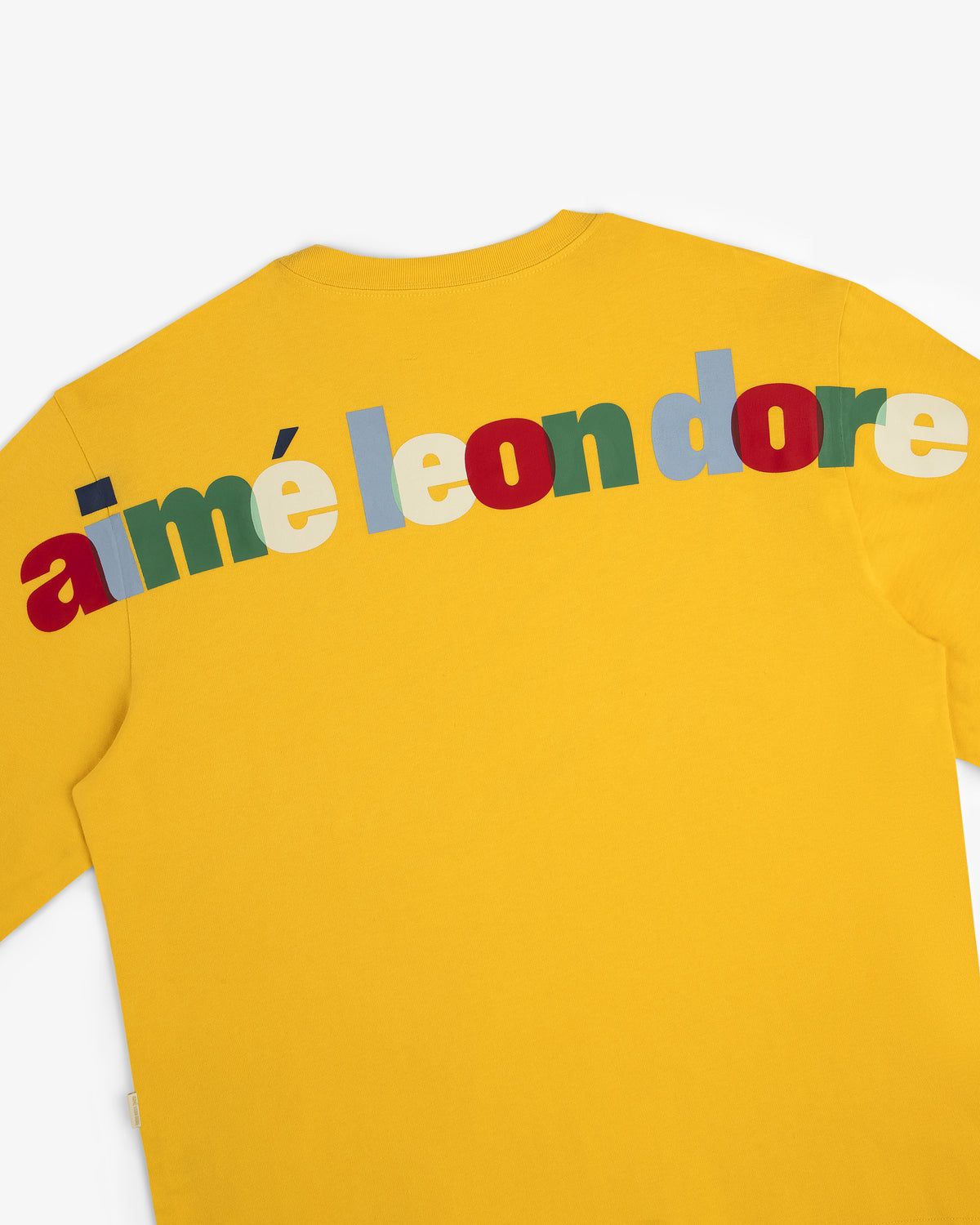 Long-Sleeve Souvenir Tee in yellow with large, colorful aimé leon dore block letters across the upper back.