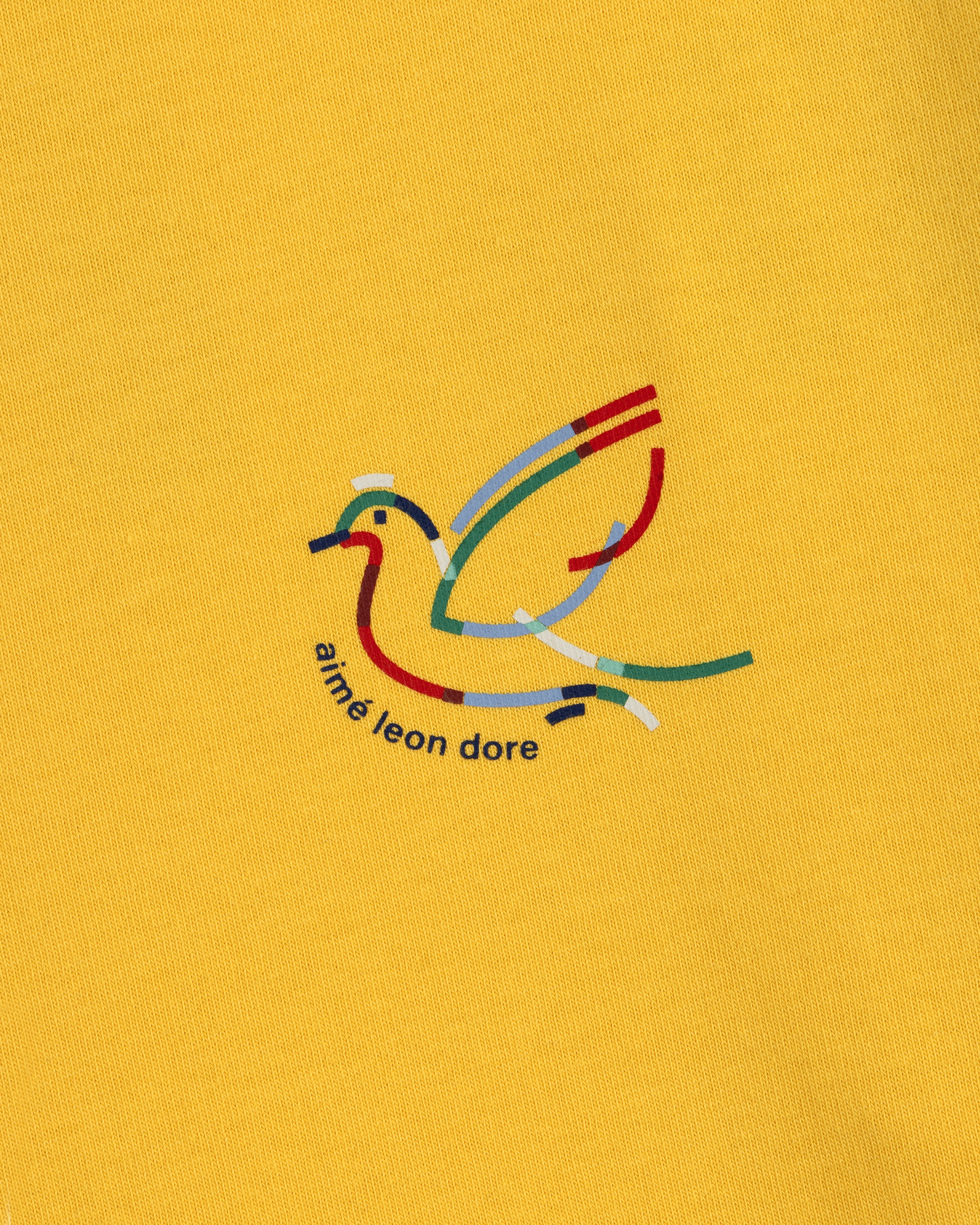 Minimalist, multicolored bird logo with aimé leon dore text on yellow Long-Sleeve Souvenir Tee.
