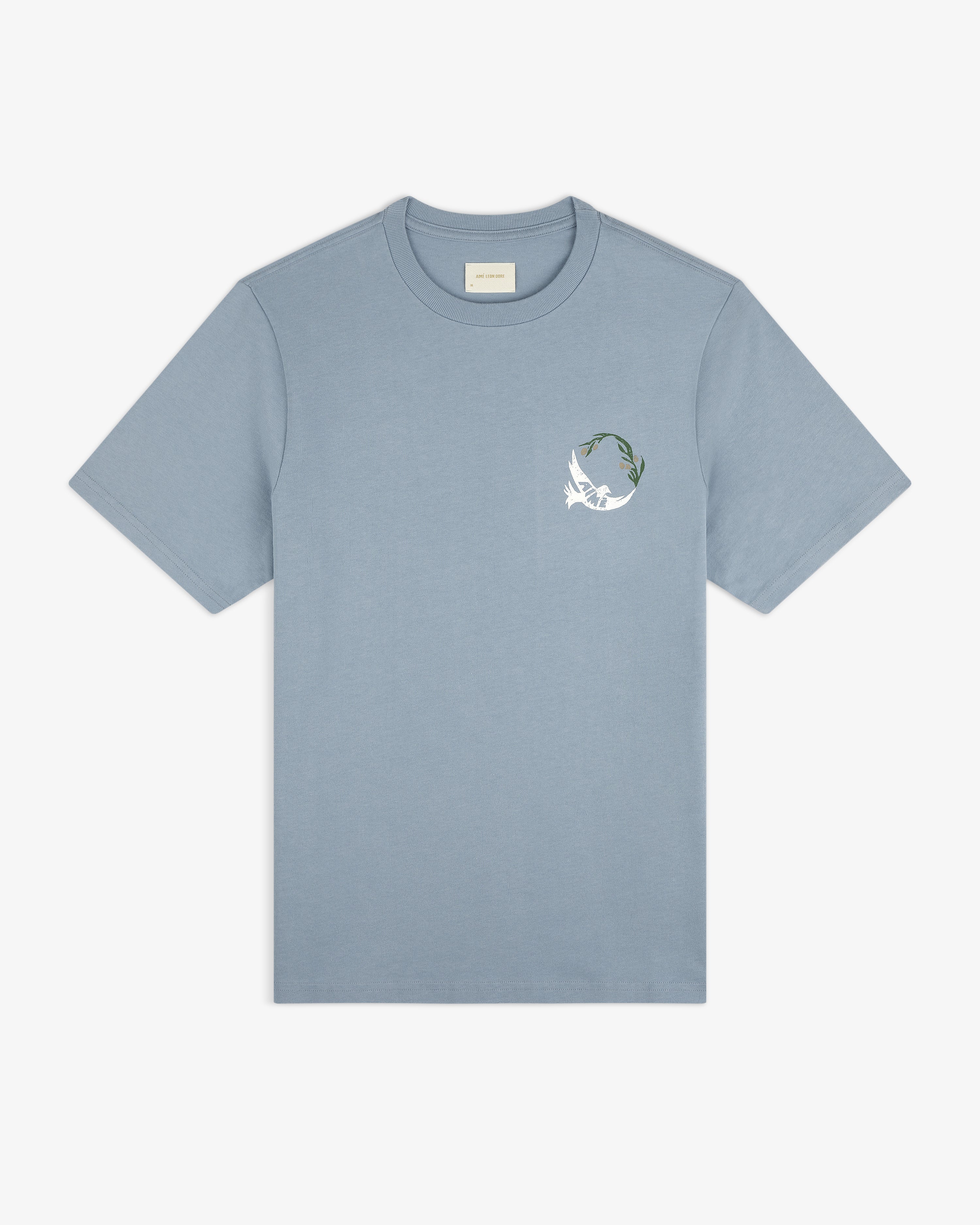 Woodblock Dove Tee: light blue short-sleeve shirt with a white bird and green leaf graphic on the left chest.