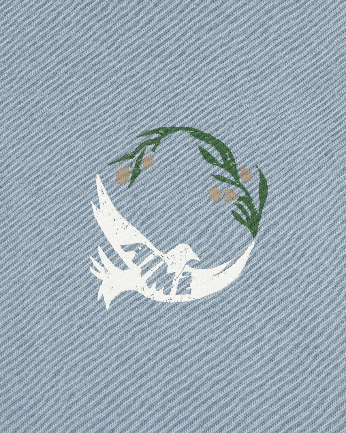 Woodblock Dove Tee features a white dove with TIME on its wing, flying beneath a green olive branch on light blue.
