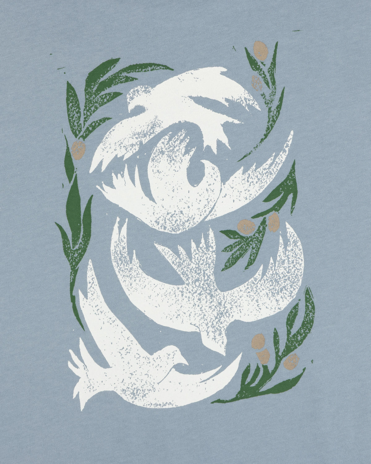 Three white doves with green olive branches on a light blue background, featured on the Woodblock Dove Tee.