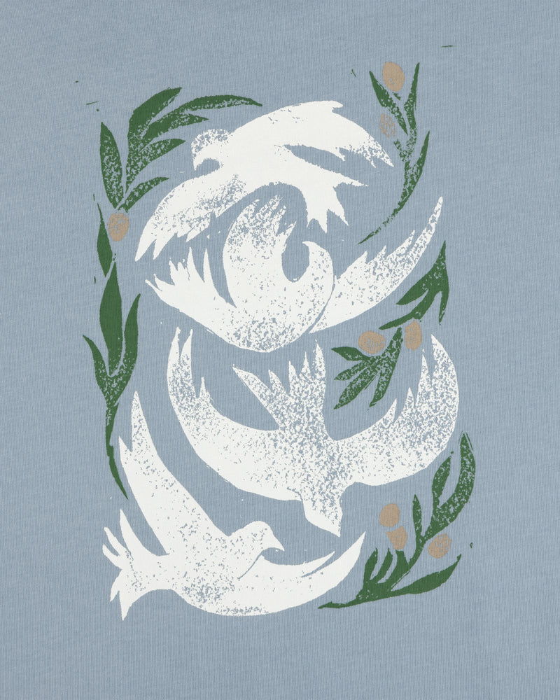 Three white doves with green olive branches on a light blue background, featured on the Woodblock Dove Tee.