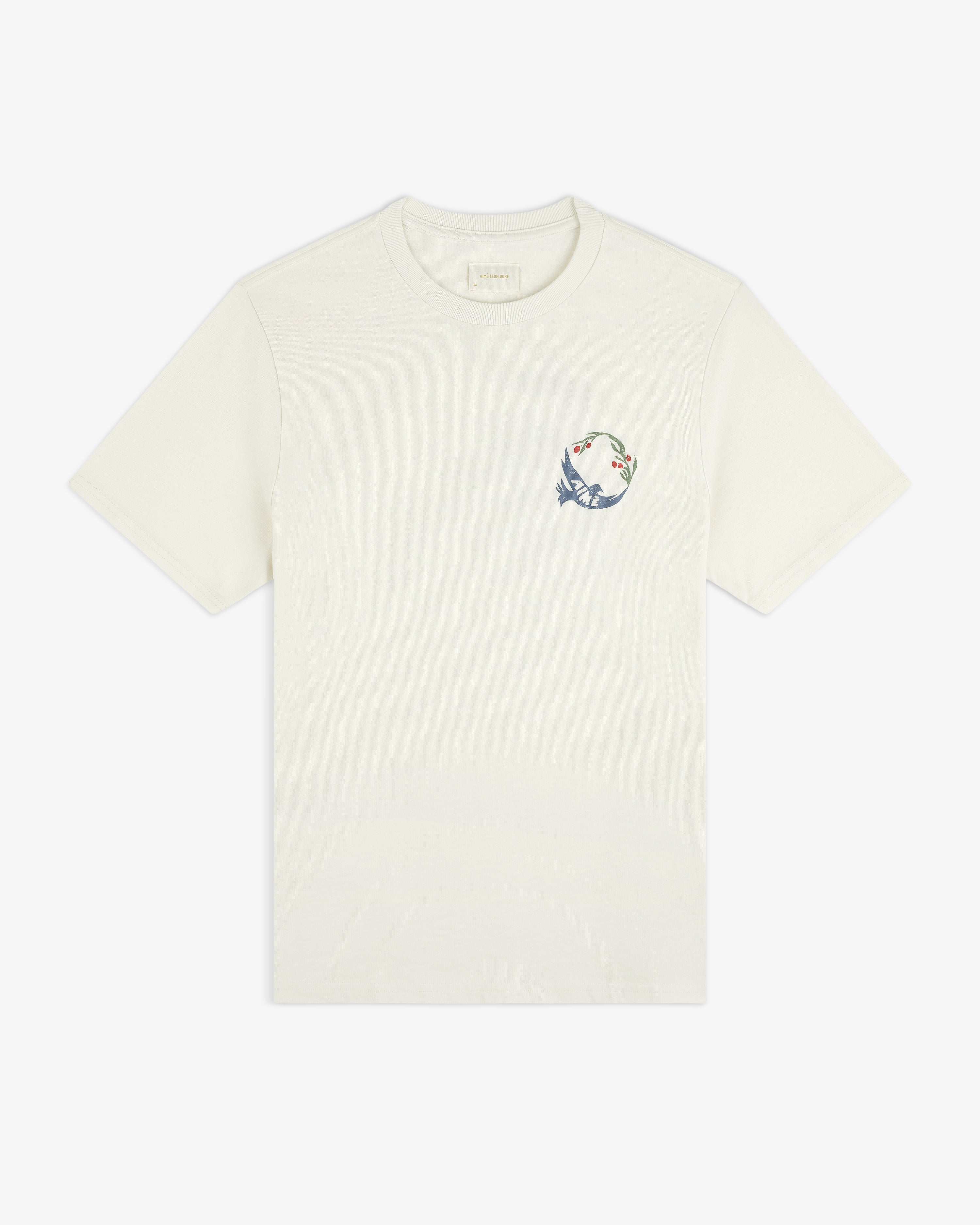 Woodblock Dove Tee: Off-white short-sleeve shirt with a small, colorful dove and floral design on the left chest.