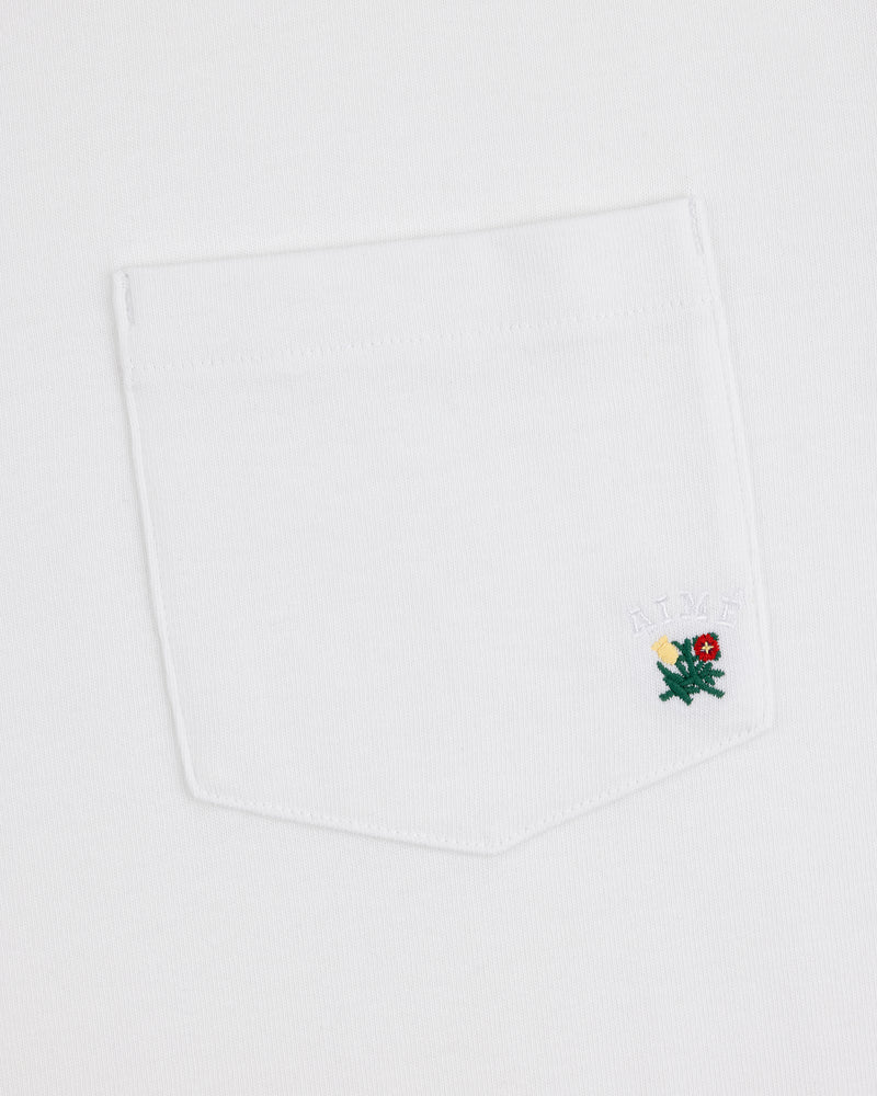 Crest Pocket Tee with a small green dragon embroidered on the pocket and "AIMÉ" stitched above in white.