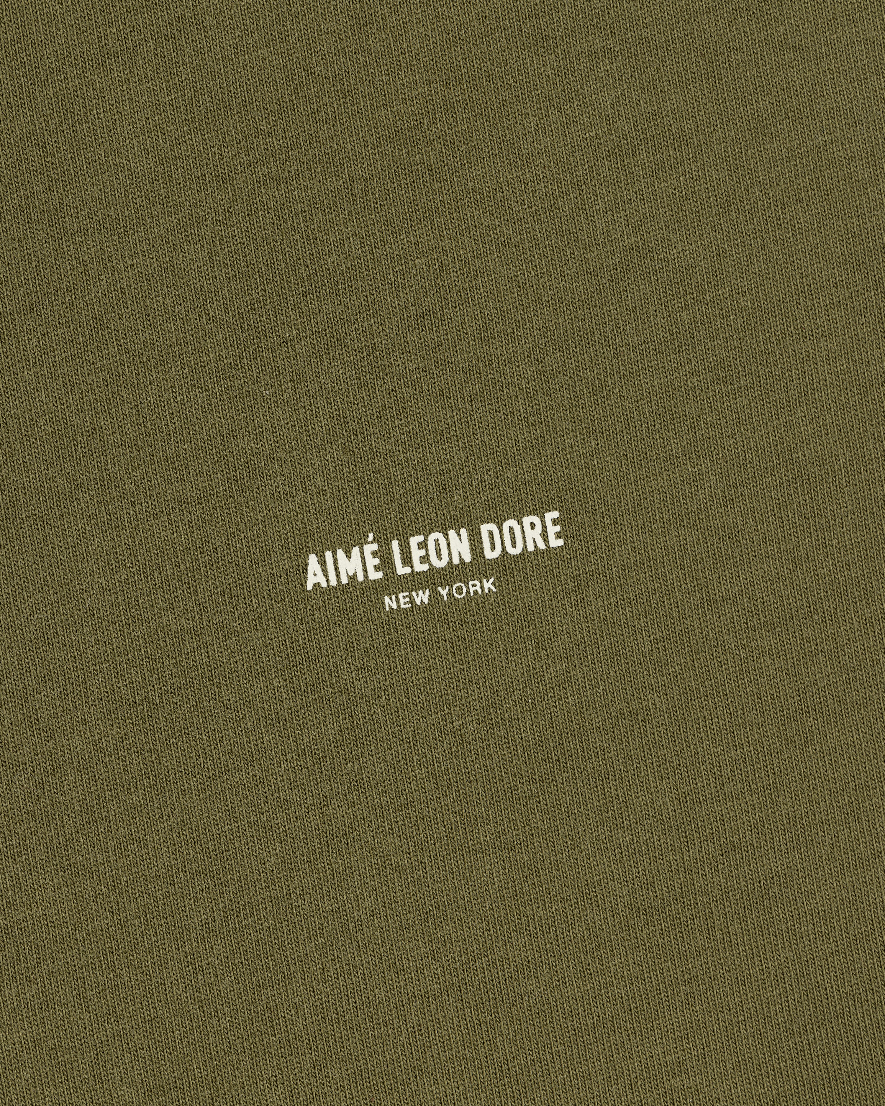 Safari Tee in olive green with AIMÉ LEON DORE NEW YORK printed in small white uppercase letters at the center.