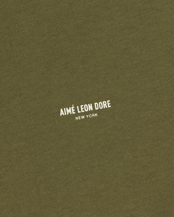 Safari Tee in olive green with AIMÉ LEON DORE NEW YORK printed in small white uppercase letters at the center.