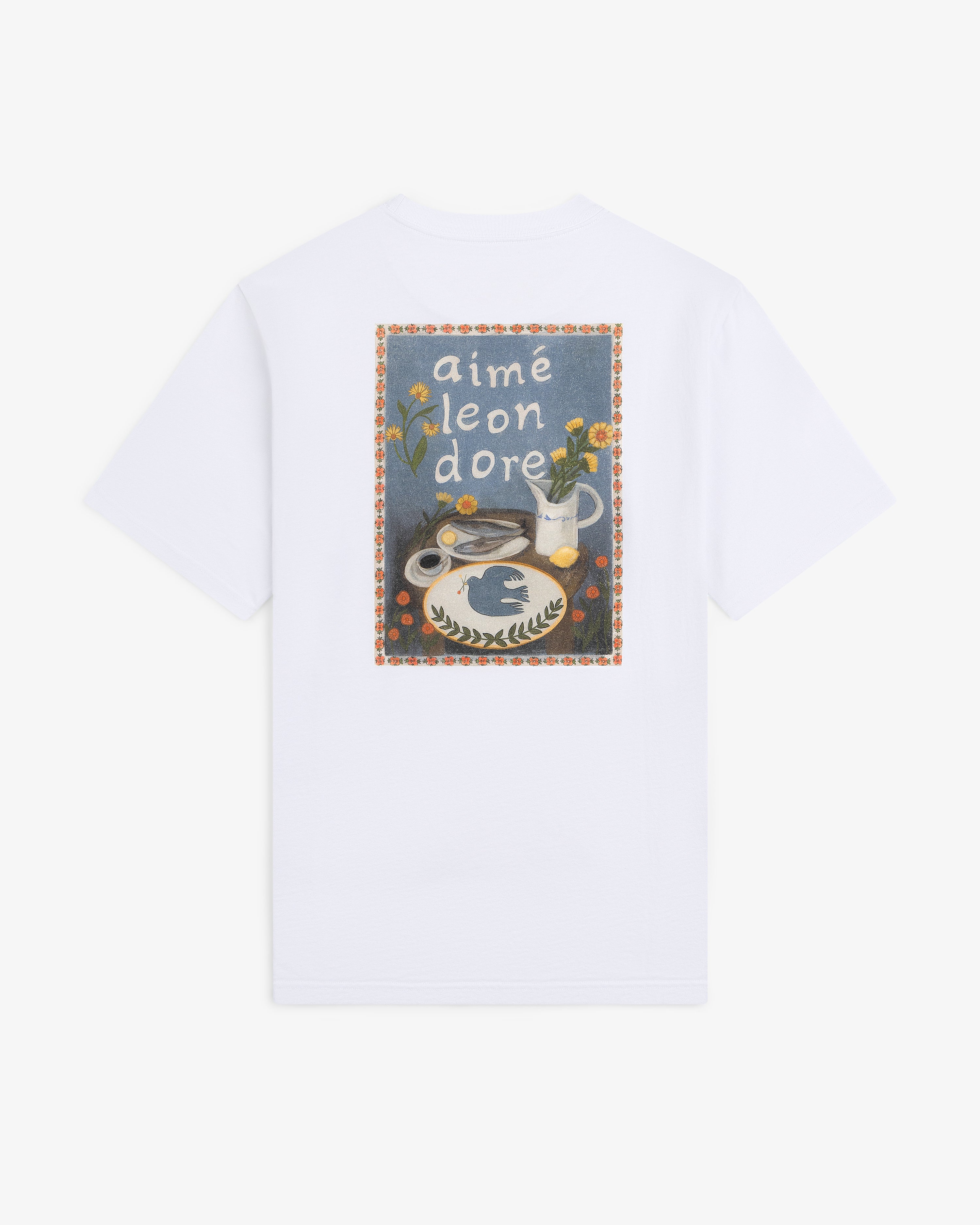 Breakfast Tee featuring a colorful graphic of flowers, vase, and food, with “aimé leon dore” text on the back.