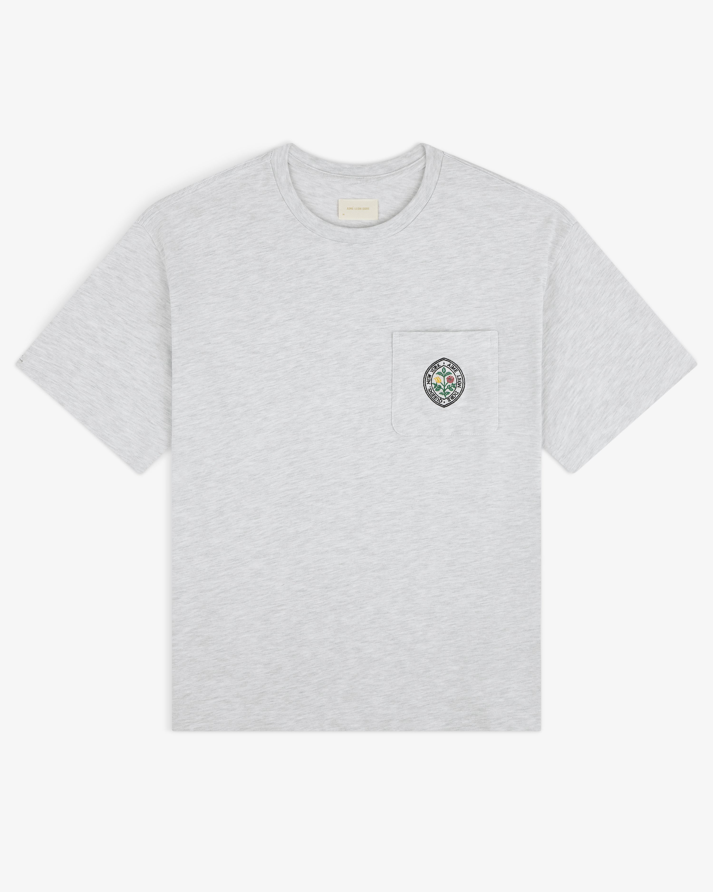 Light gray Botanical Crest Pocket Tee with short sleeves and a chest pocket featuring a small colorful crest.
