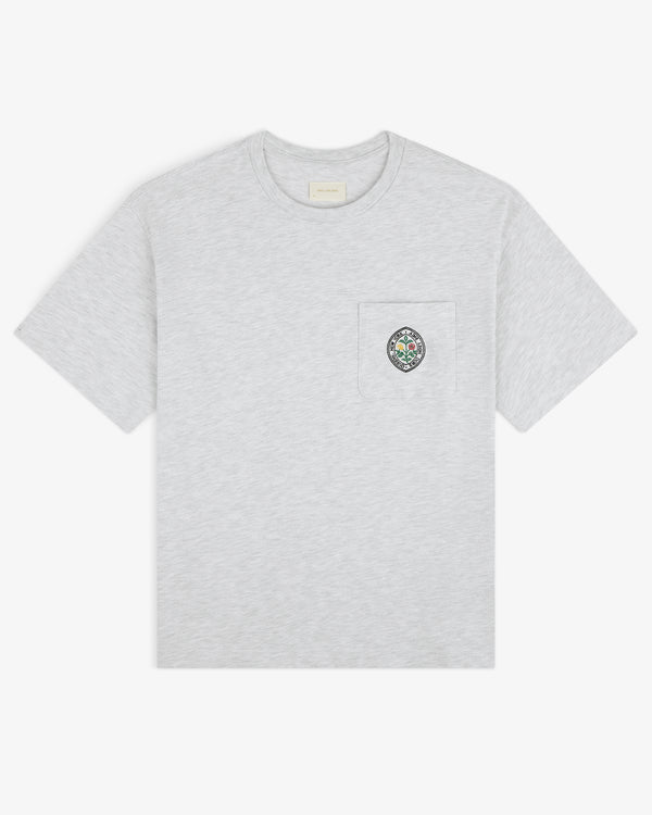 Light gray Botanical Crest Pocket Tee with short sleeves and a chest pocket featuring a small colorful crest.