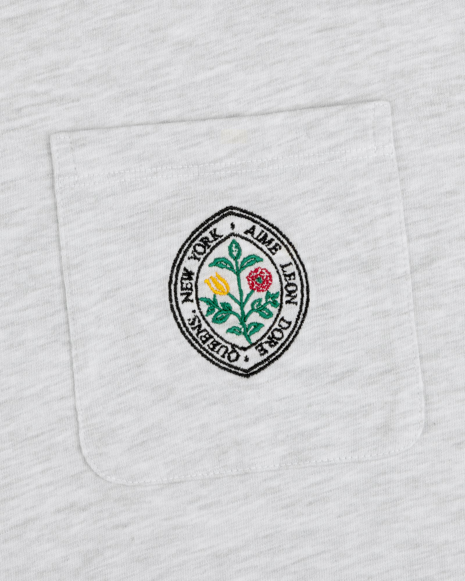 Botanical Crest Pocket Tee with a circular floral patch and “Aime Leon Dore New York Queens” text on the pocket.