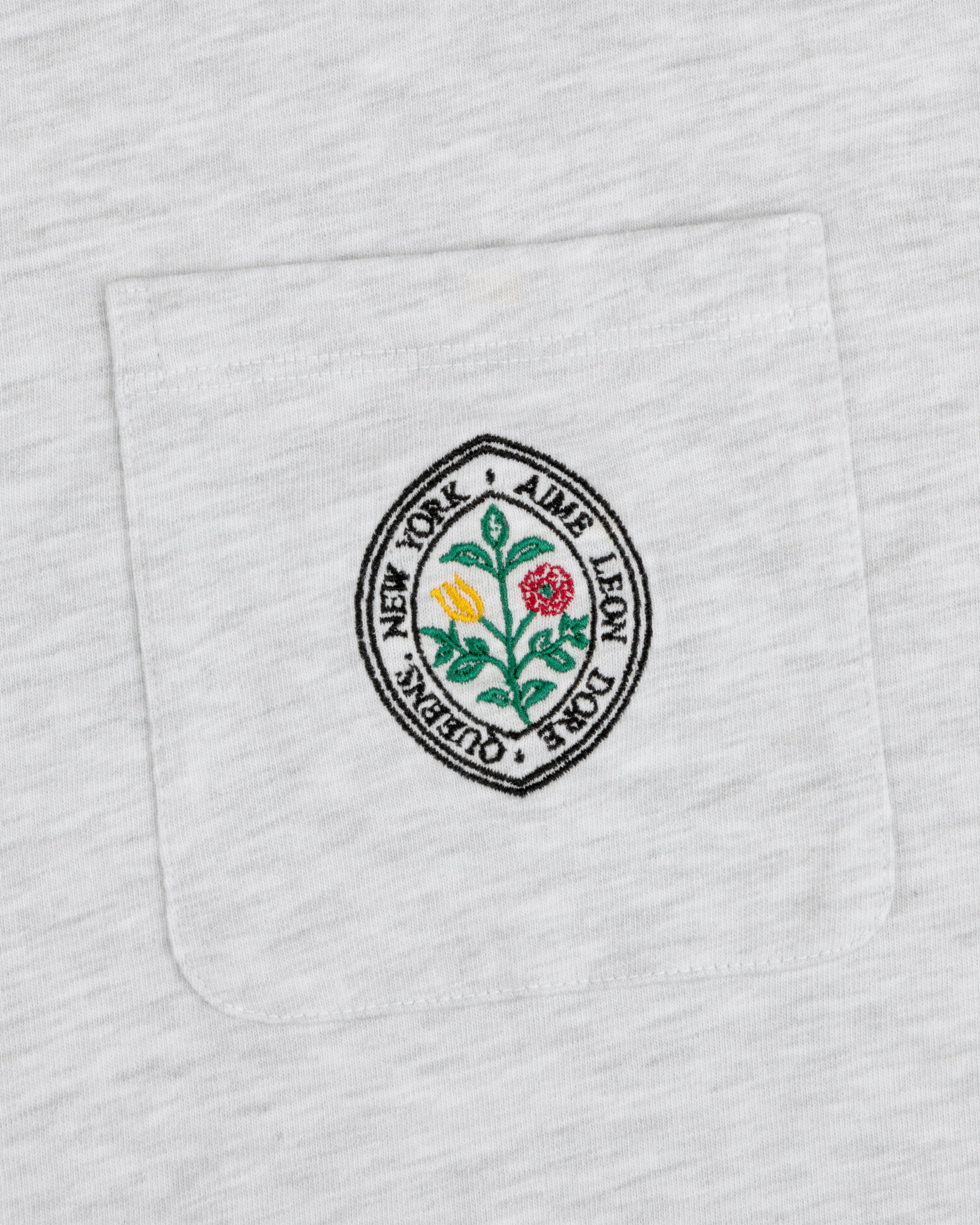 Botanical Crest Pocket Tee with a circular floral patch and “Aime Leon Dore New York Queens” text on the pocket.