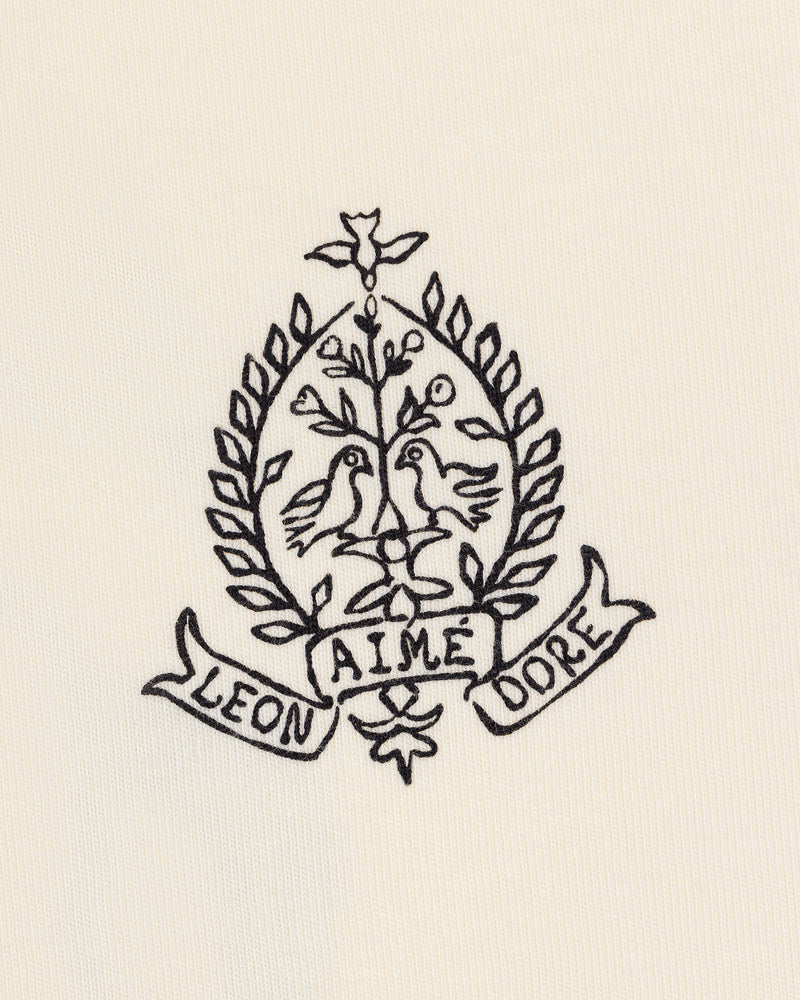Cream Saint George Graphic Tee with embroidered crest featuring two birds, a tree, laurels, and “Aime Leon Dore” banner.