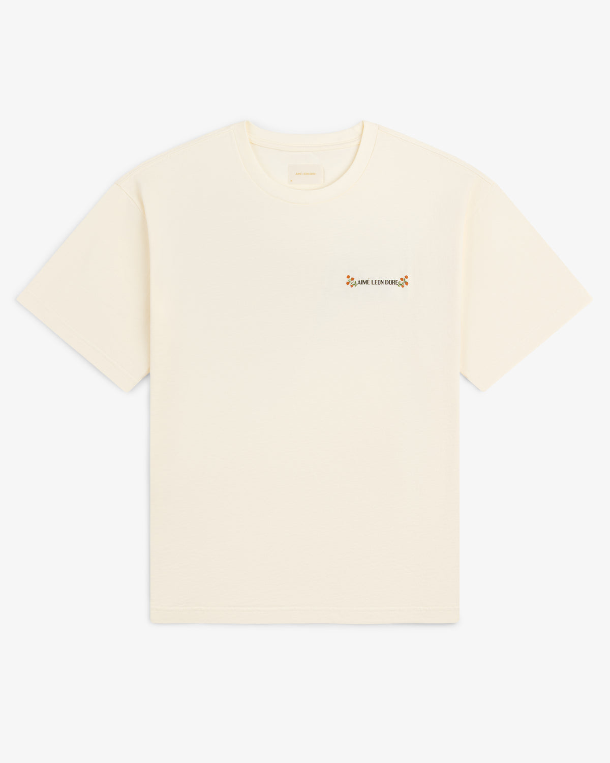 Aimé Postcard Tee: cream short-sleeve shirt with small text and a flower on the left chest.