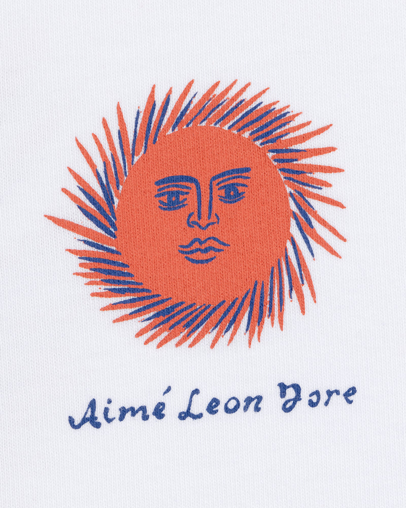 Illustration of an orange sun with a face and blue rays on the Fassianos "Sovereign Sun" Tee by Aimé Leon Dore.