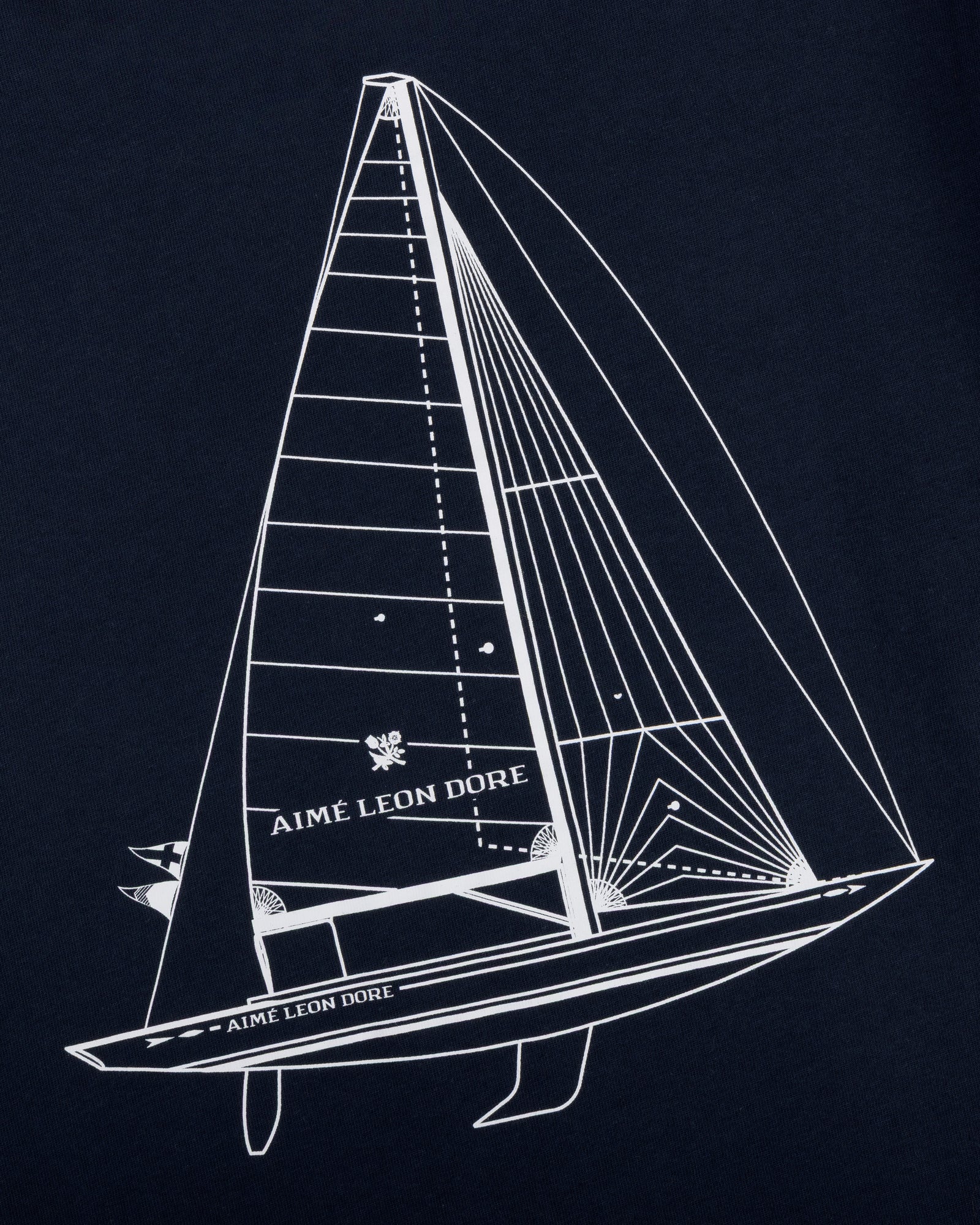 White line sailboat and AIMÉ LEON DORE text on dark blue Marina Tee.