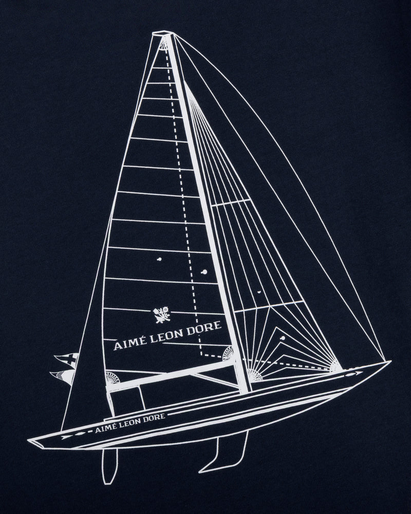 White line sailboat and AIMÉ LEON DORE text on dark blue Marina Tee.