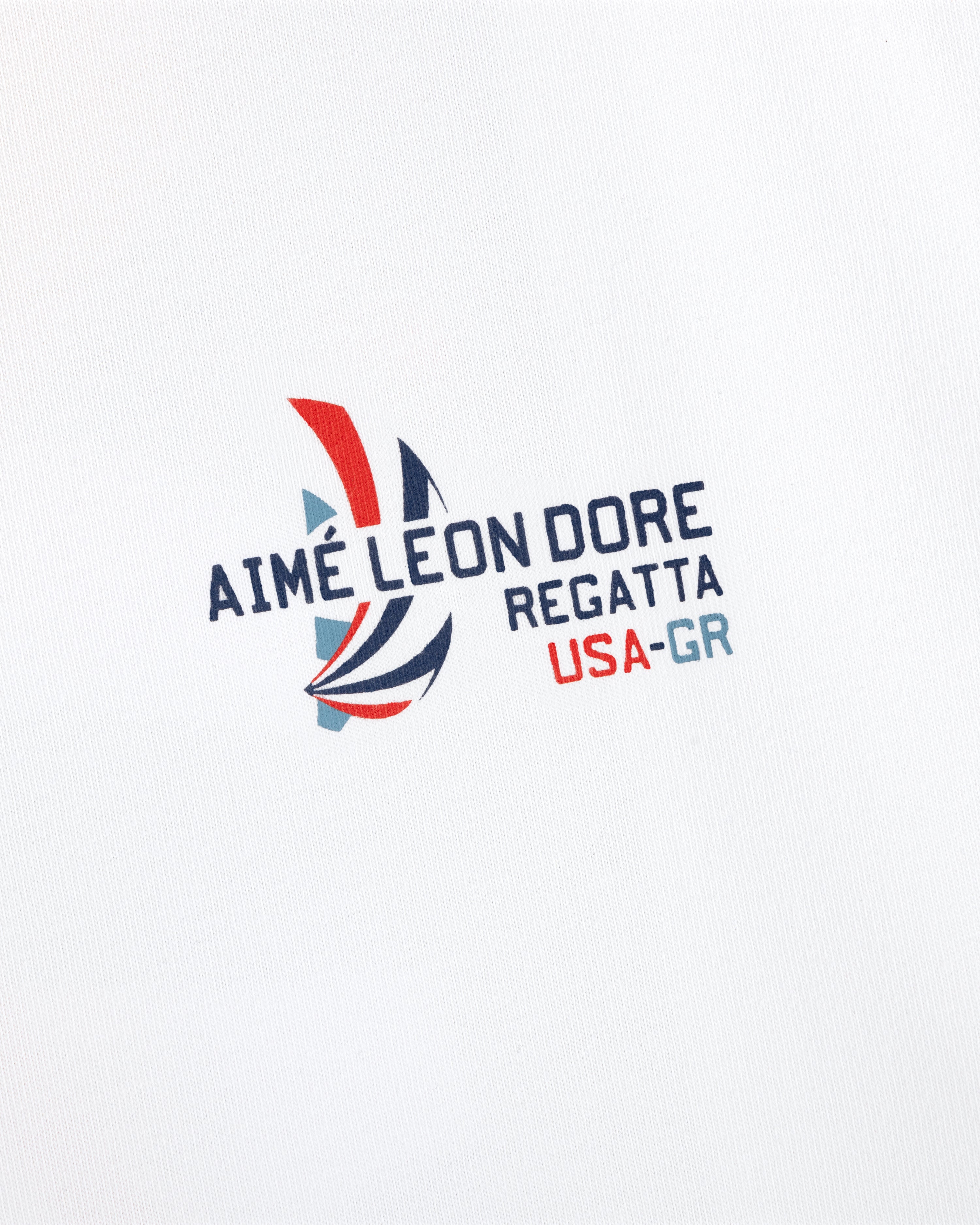 Regatta Tee with Aimé Leon Dore sailboat logo and USA-GR text on a white background.