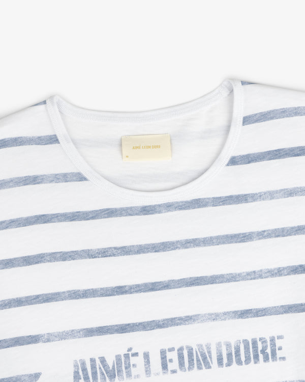 Slub Beach Tee: White T-shirt with light blue stripes and visible Aimé Leon Dore label inside the collar.
