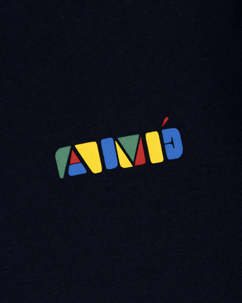 The Stacked Logo Tee features the word AIMÉ in colorful, geometric block letters on a dark fabric background.