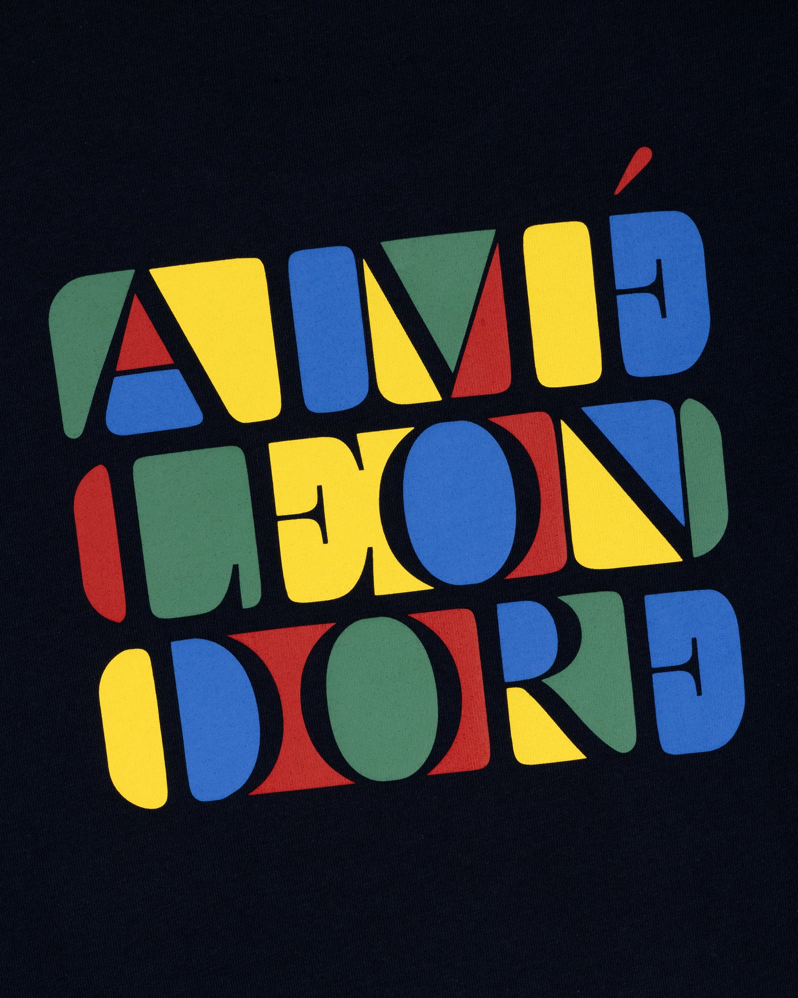 Bold, colorful “Stacked Logo Tee” text in red, yellow, blue, and green geometric letters on a black background.