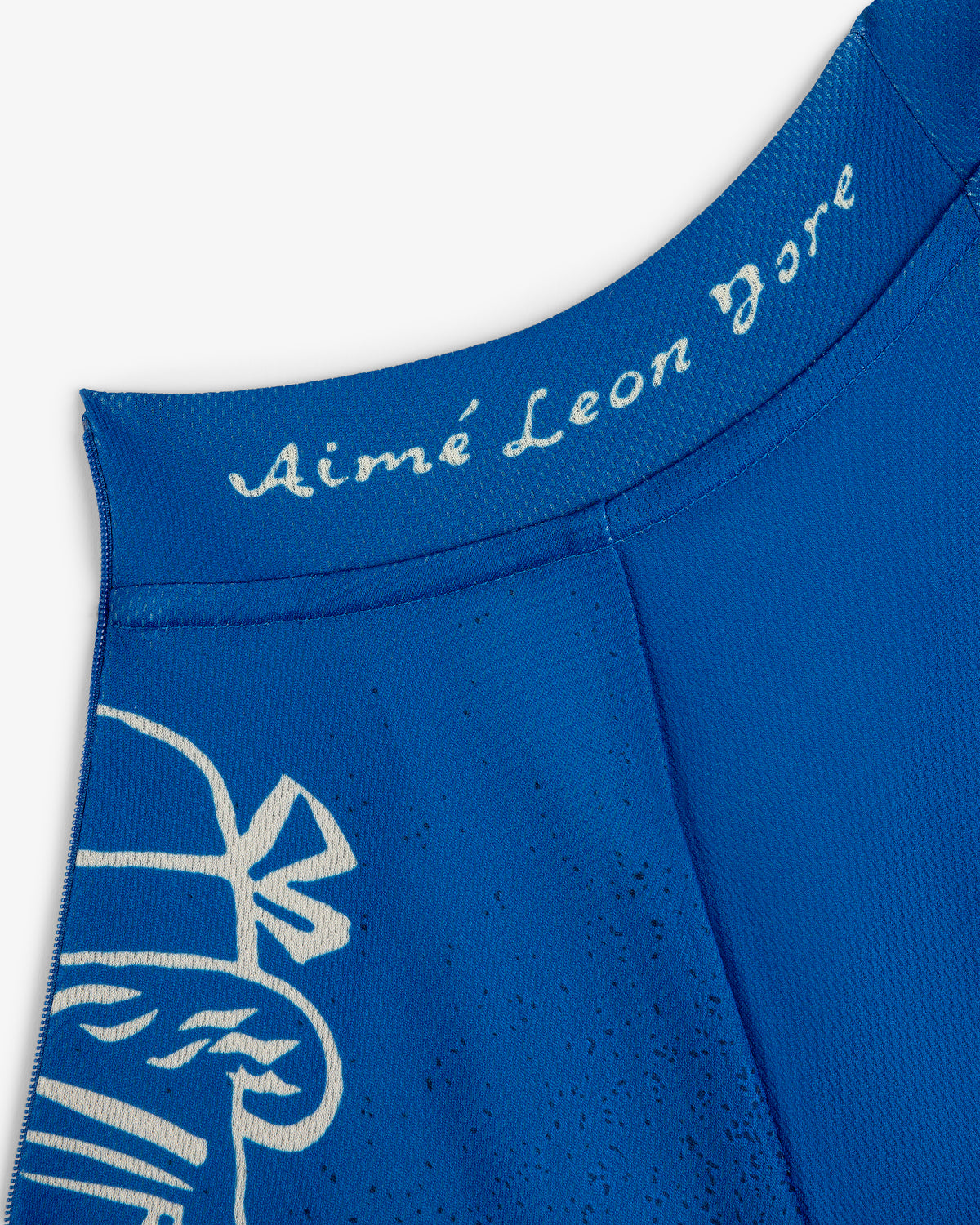 Close-up of a blue Fassianos Half-Zip Cycling Jersey with Aimé Leon Dore in white script near the collar and a white graphic.