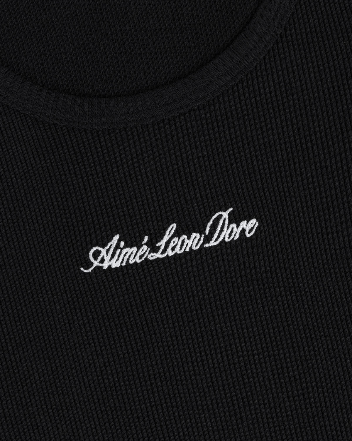 Close-up of black ribbed Embroidered Logo Tank Top with Aimé Leon Dore in white cursive text.
