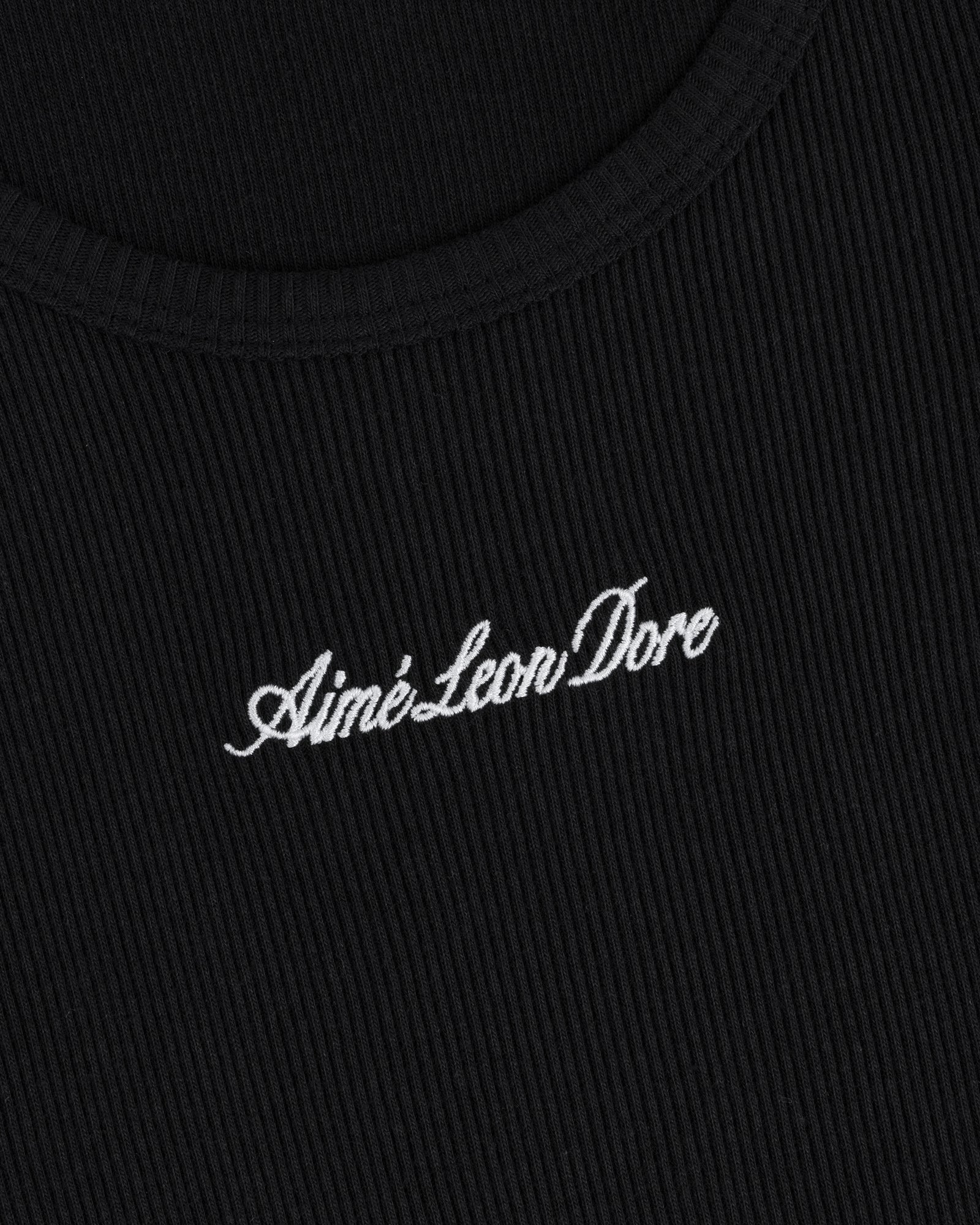 Close-up of black ribbed Embroidered Logo Tank Top with Aimé Leon Dore in white cursive text.