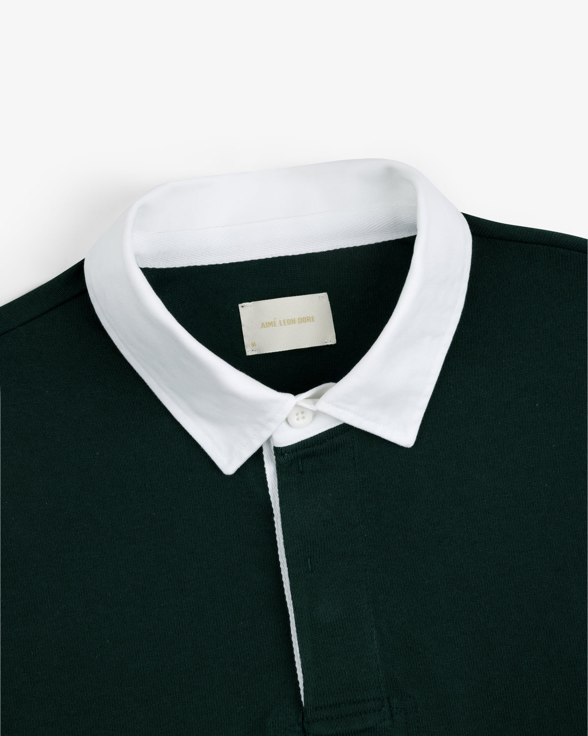 Dark green Script Paneled Rugby with a white collar and an inside label reading ACME LION DESIGN.