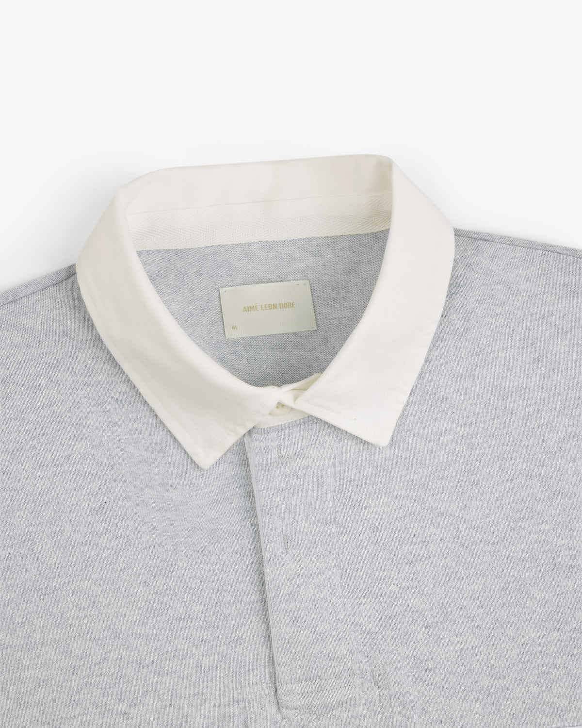 Script Paneled Rugby in light grey with a white collar, viewed from above on a white background.