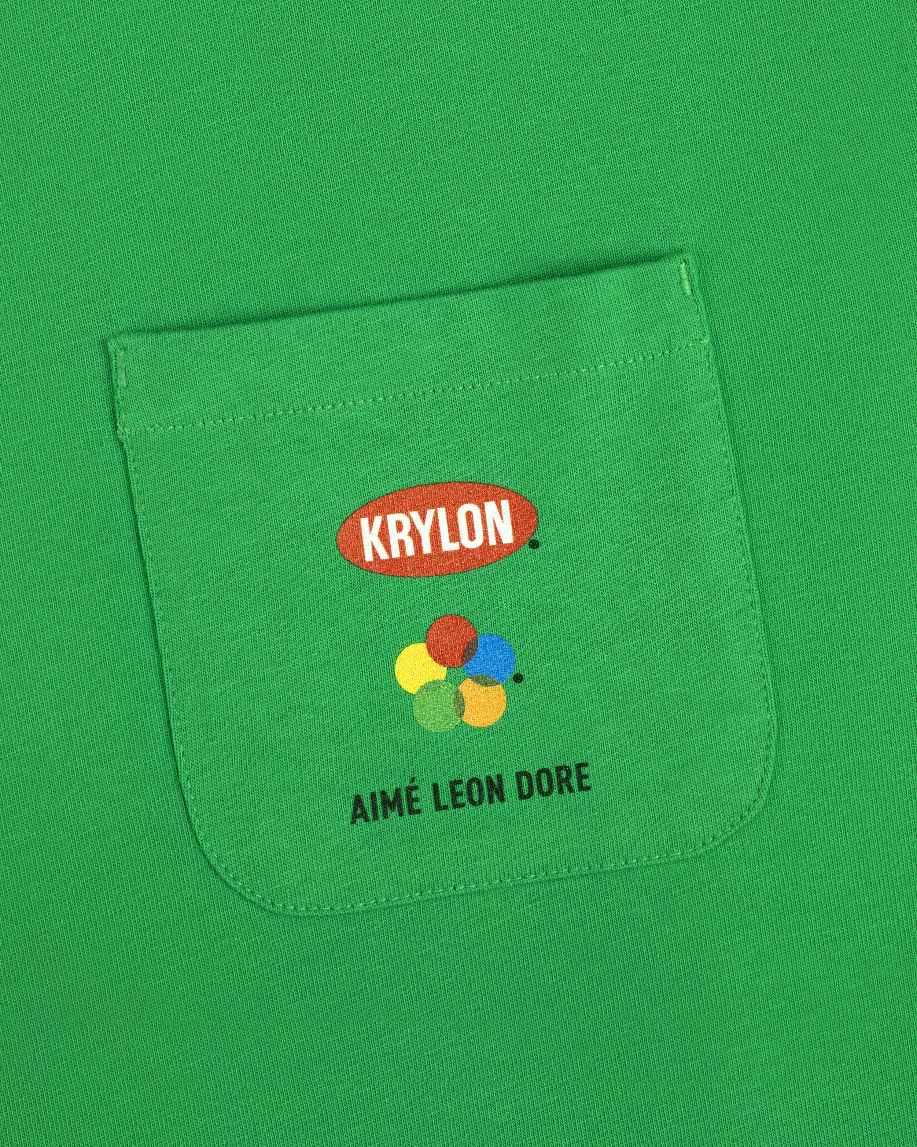 Krylon Pocket Tee with colorful paint dots and AIMÉ LEON DORE printed on the green shirt pocket.