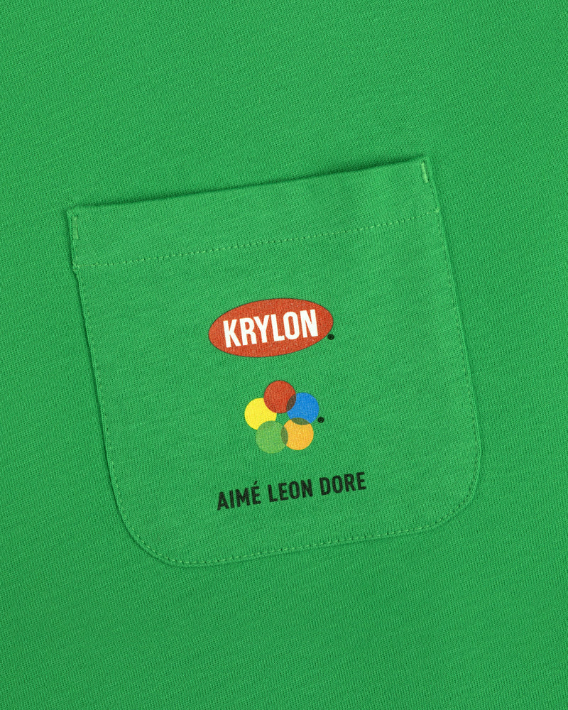 Krylon Pocket Tee with colorful paint dots and AIMÉ LEON DORE printed on the green shirt pocket.